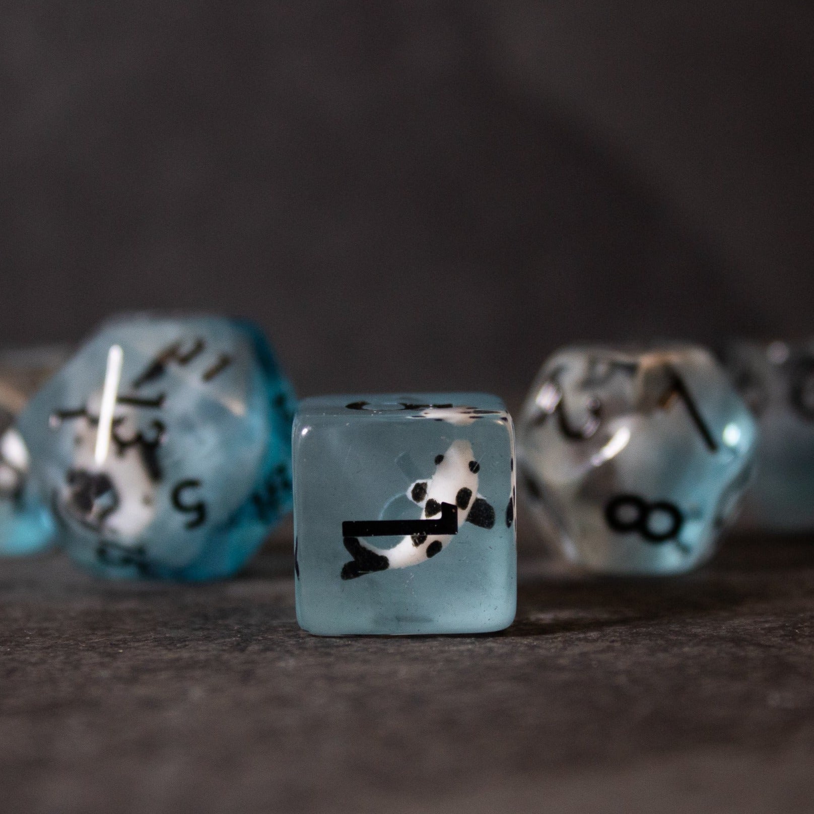 Black Koi & Steel Blue Dice - Translucent steel blue dice set with black koi fish inclusions and white numbering.
