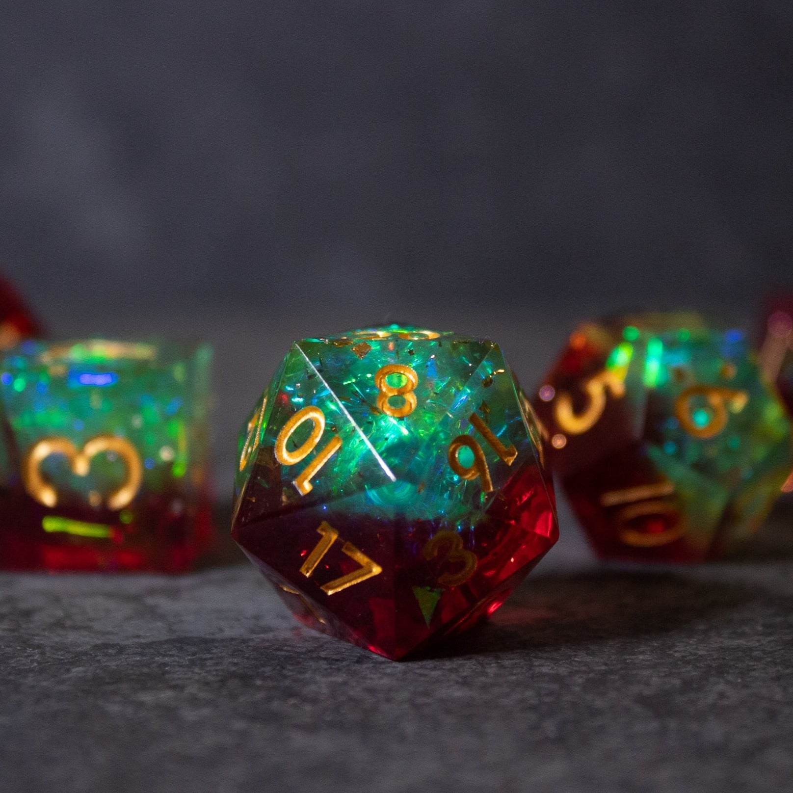 Fairy Fire - Sharp Edge Opalescent Dice - Opalescent 20-sided dice with sharp edges in green and red hues featuring gold numbers.