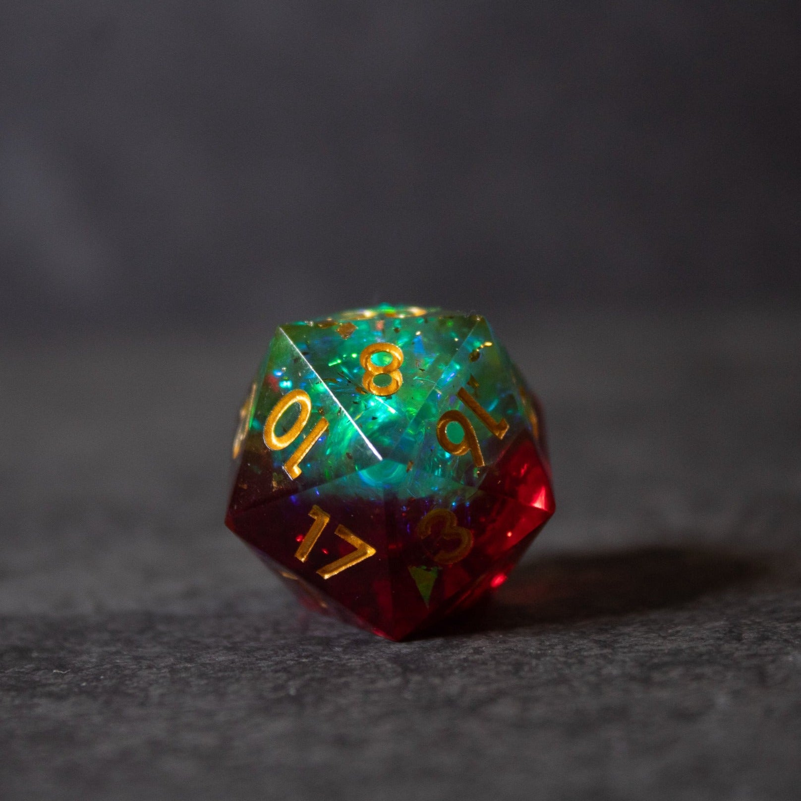 Fairy Fire - Sharp Edge Opalescent Dice - Twenty-sided dice with sharp edges, swirling green and red opalescent colors, gold numbering.
