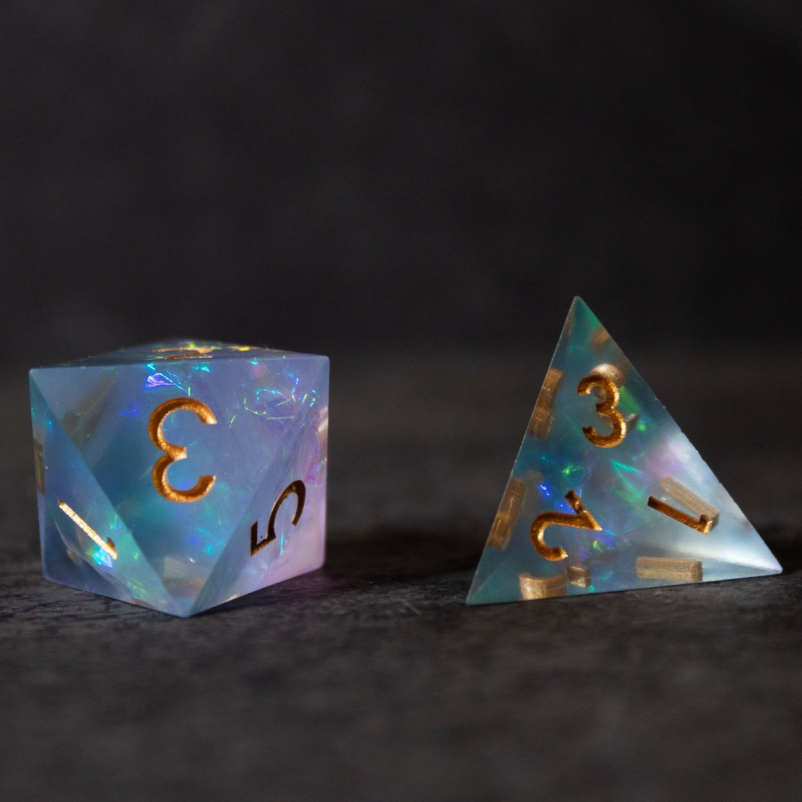 Frost Fire - Sharp Edge Opalescent Dice - Opalescent frosted blue and white sharp-edge dice with gold numbers, one d20 and one d4.