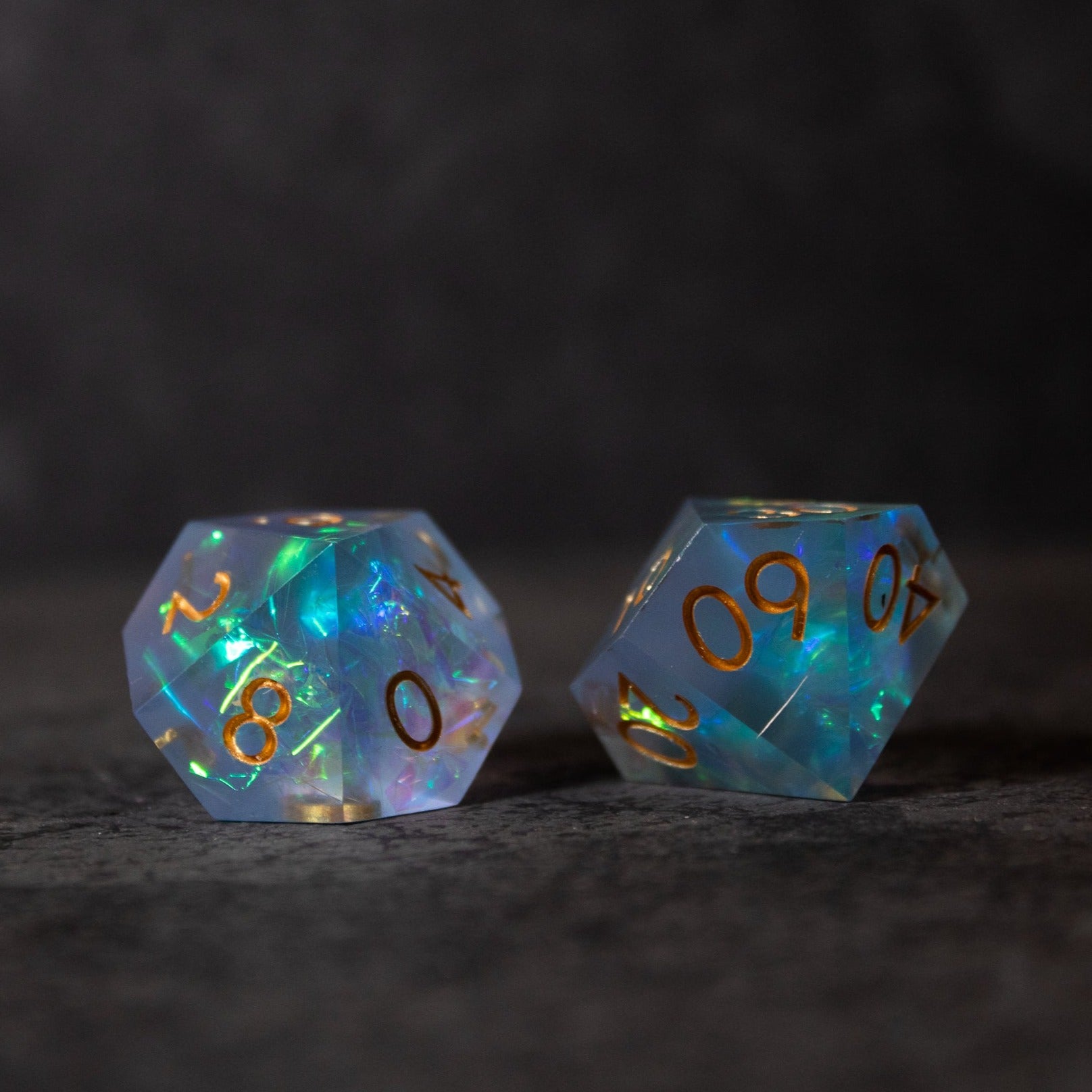 Frost Fire - Sharp Edge Opalescent Dice - Two translucent opalescent 20-sided dice with sharp edges, glowing blue and white with gold numbers.