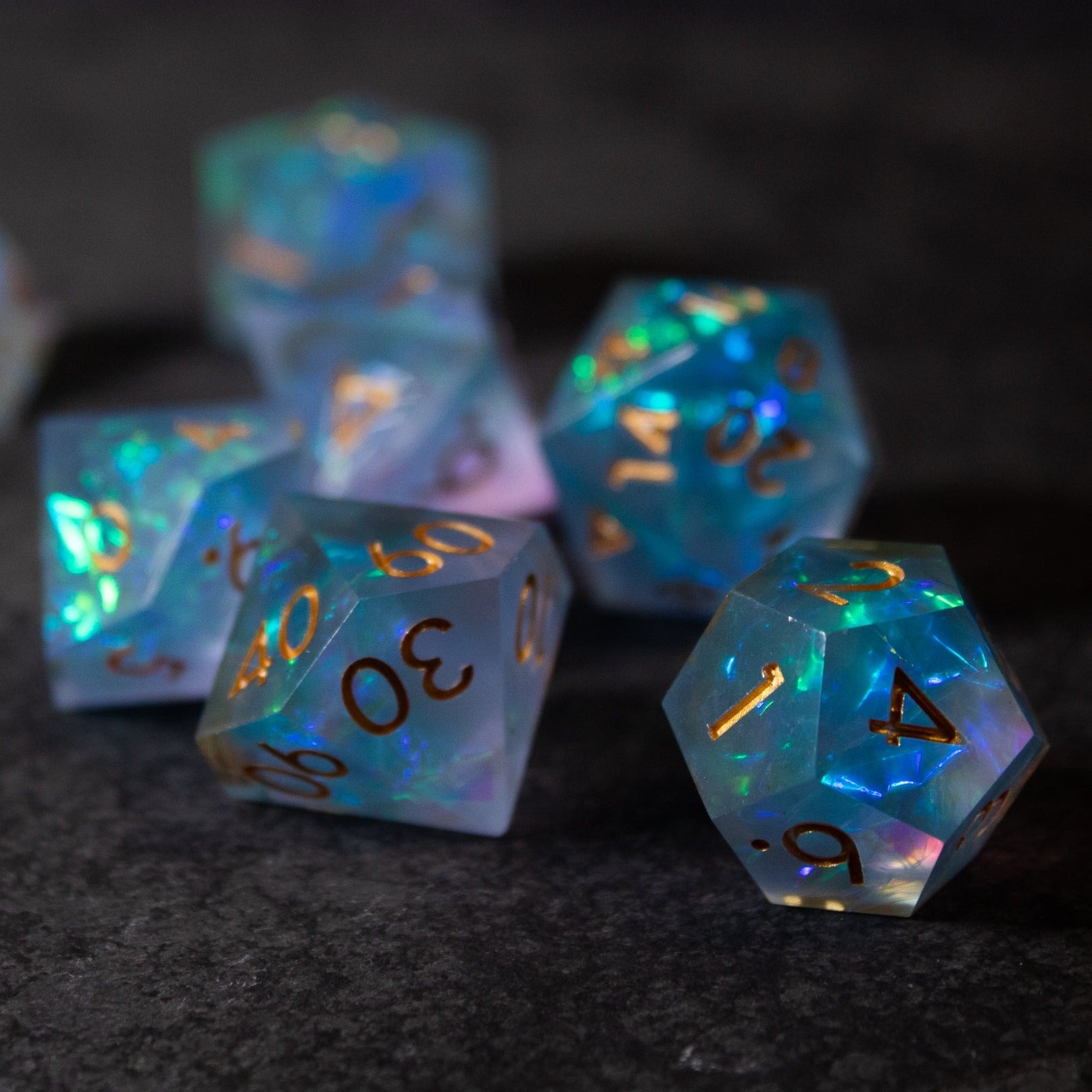 Frost Fire - Sharp Edge Opalescent Dice - Set of translucent sharp-edged dice with opalescent blue, green, and purple hues and gold numbering.