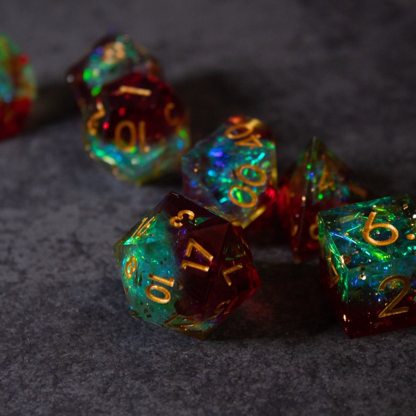 Fairy Fire - Sharp Edge Opalescent Dice - Set of sharp-edged polyhedral dice with opalescent green, blue, and red hues and gold numbering.