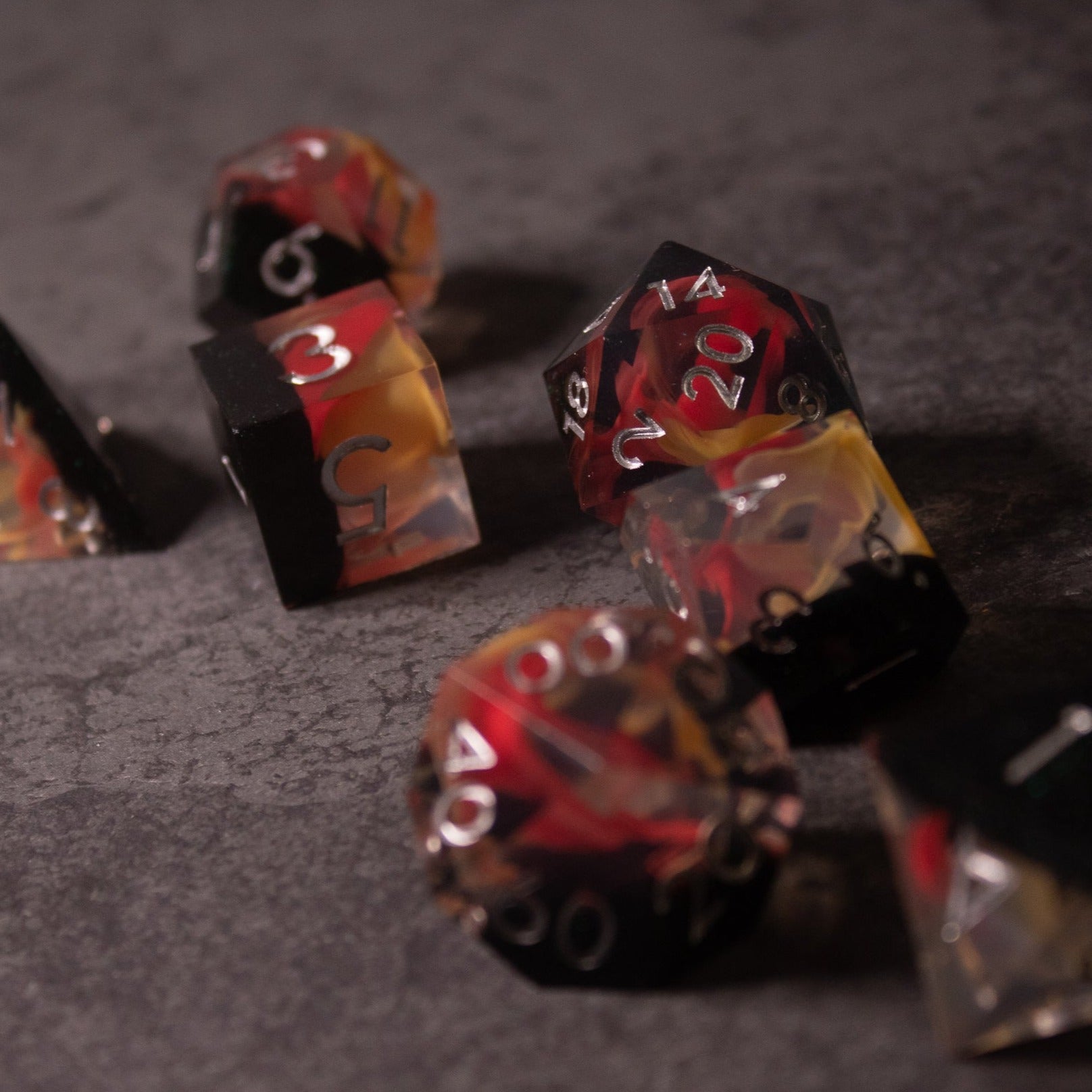 Widowgast's Flame - Sharp Edge Dice - Sharp-edged translucent red and black polyhedral dice set with fiery orange and yellow swirls.