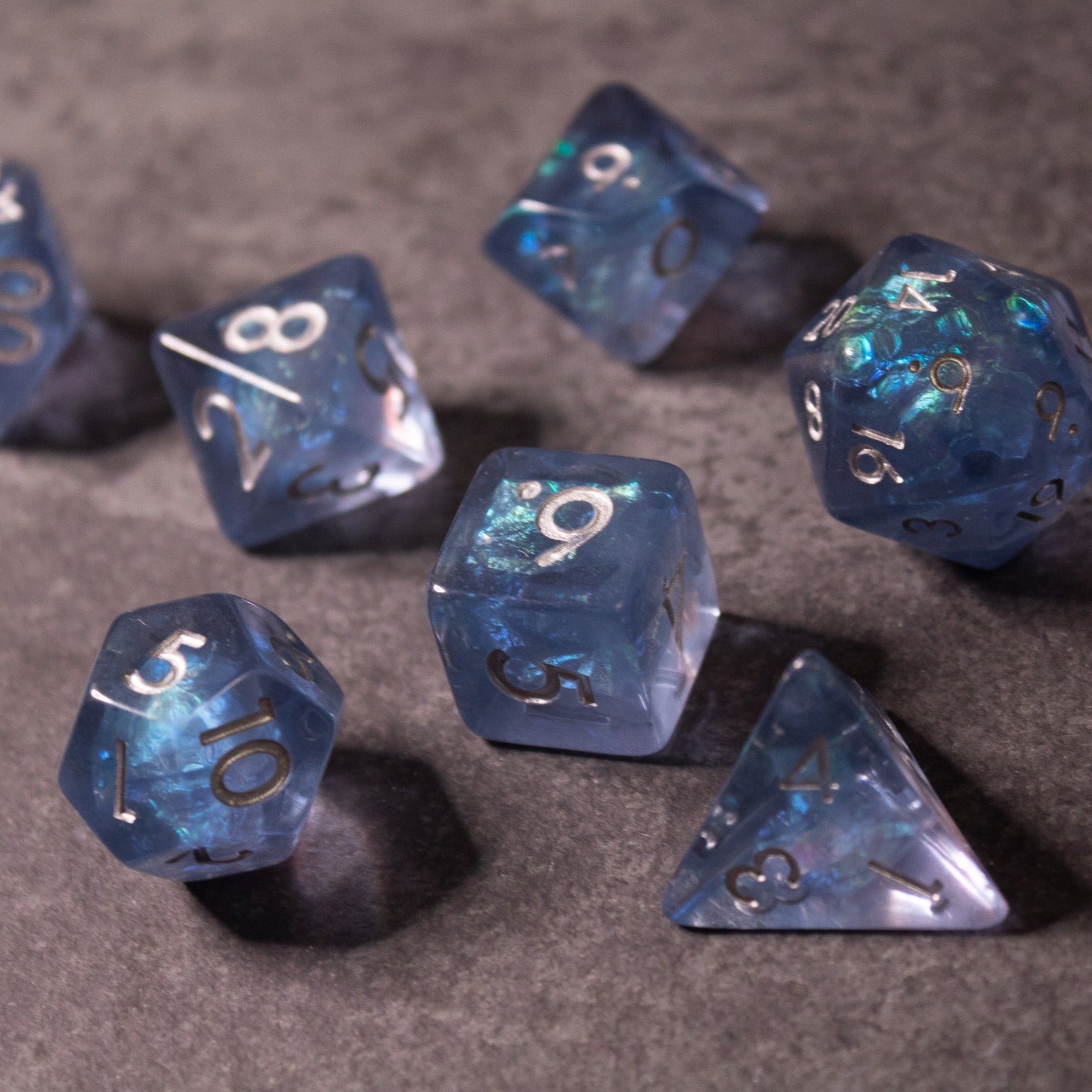 Glacier Ice Dice Set - Set of translucent blue polyhedral dice with iridescent inclusions and silver numbering.