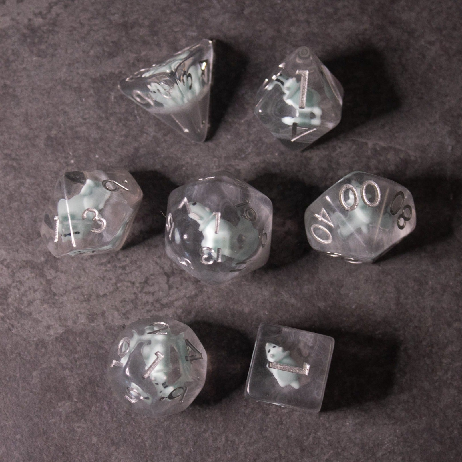 Dinosaur Dice Set - Triceratops - Clear polyhedral dice set featuring white numbers and embedded miniature triceratops figures inside each die.