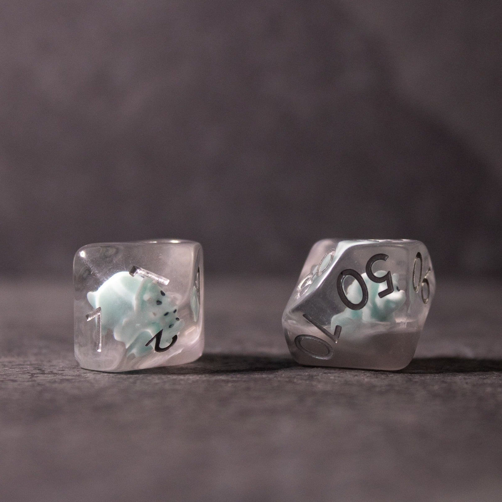 Dinosaur Dice Set - Triceratops - Clear d20 dice with a small blue triceratops figurine inside and black numbering.