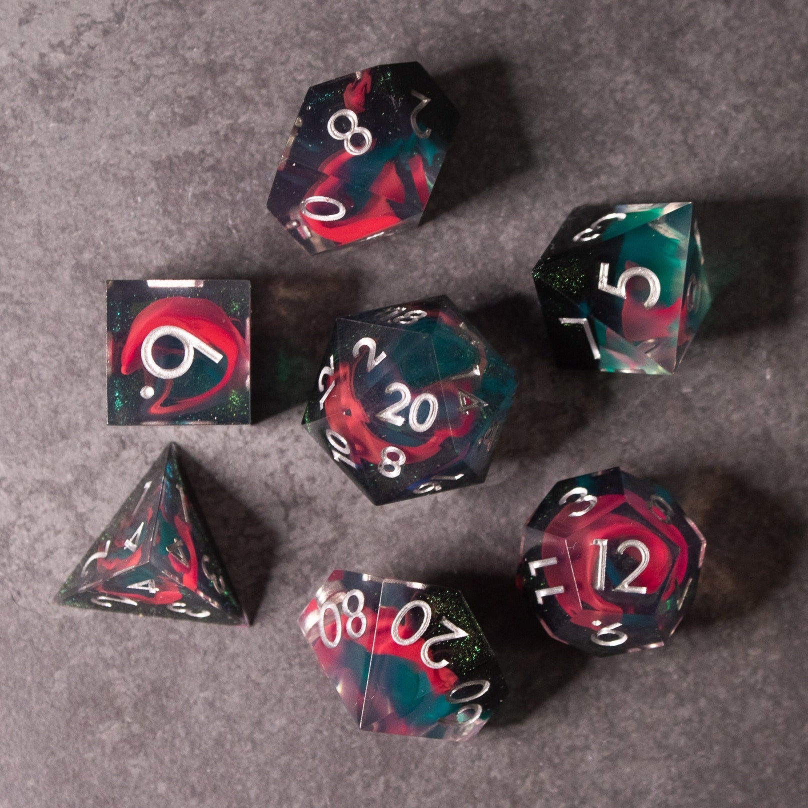 Pink & Green Flame Sharp Edge Dice Set - Sharp-edged polyhedral dice set with swirling pink and green marbled design and white numbers.