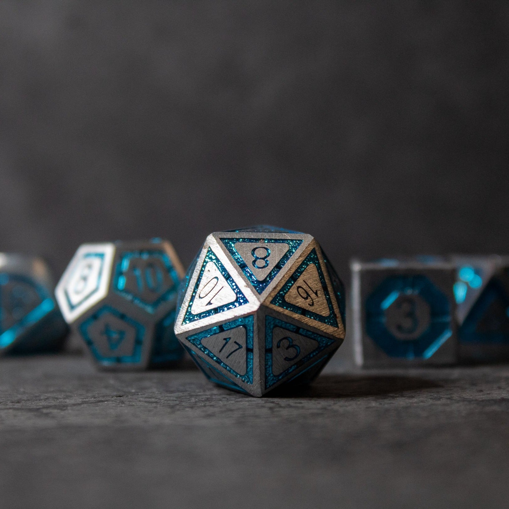 Cobalt Core Metal Dice Set - Blue and silver metal 20-sided dice with engraved numbers and geometric designs.