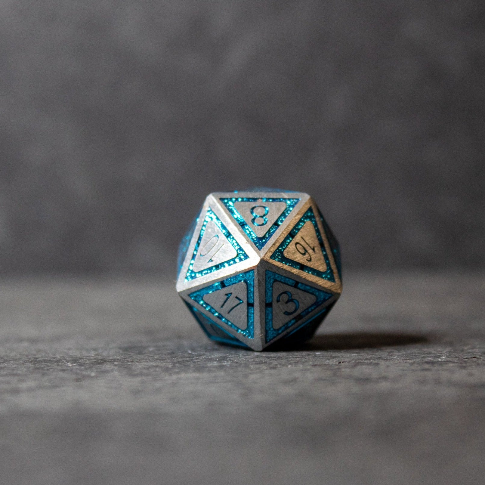Cobalt Core Metal Dice Set - Metal d20 dice with cobalt blue edges and silver faces, engraved numbers filled with blue paint.