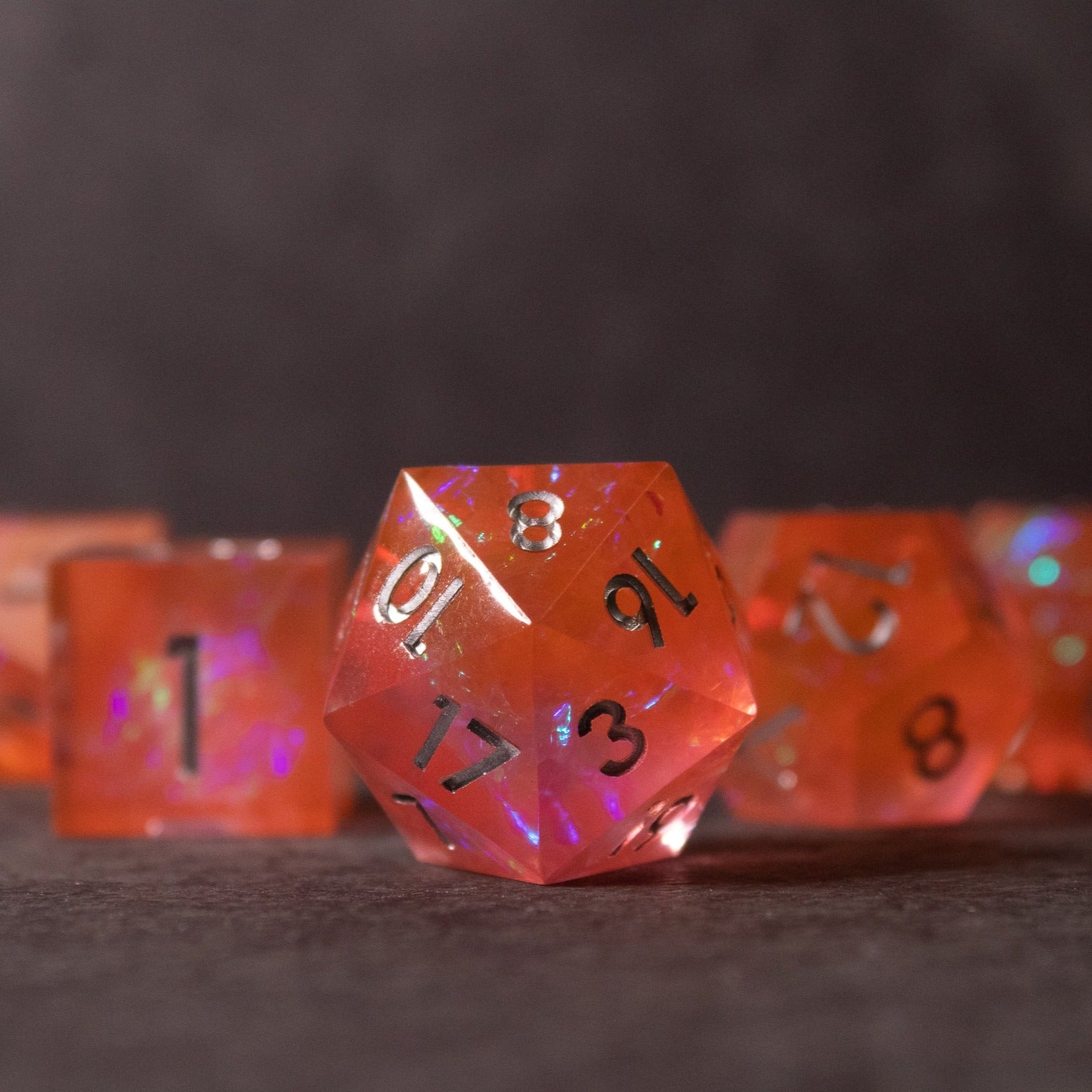 Heart Fire - Opalescent Sharp Edge Dice Set - Translucent fiery orange 20-sided sharp edge dice with black numbers and iridescent opalescent highlights.