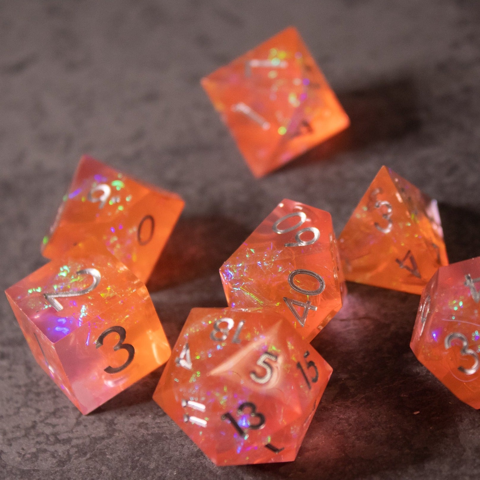 Heart Fire - Opalescent Sharp Edge Dice Set - Set of translucent orange sharp edge dice with opalescent iridescent flakes and black numbering.