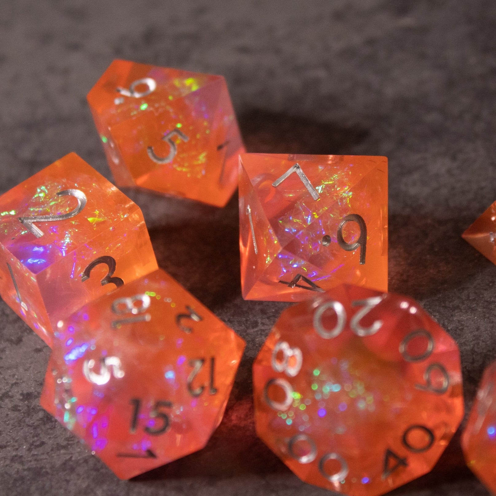 Heart Fire - Opalescent Sharp Edge Dice Set - Translucent orange twenty-sided dice set with sharp edges, featuring opalescent glitter and white numbering.