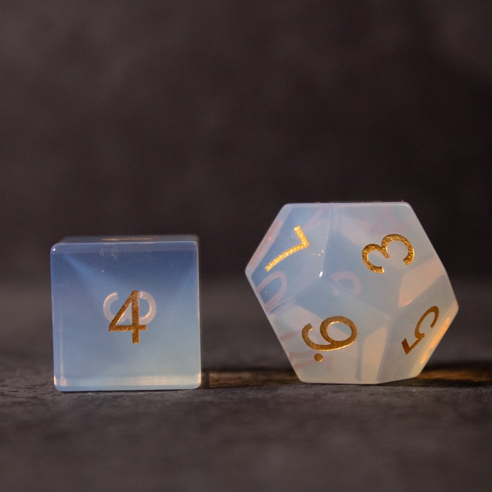 Opalite Gemstone Dice Set - Opalite gemstone dice set with translucent milky blue tones and gold numbers, featuring a six-sided and a twenty-sided die.