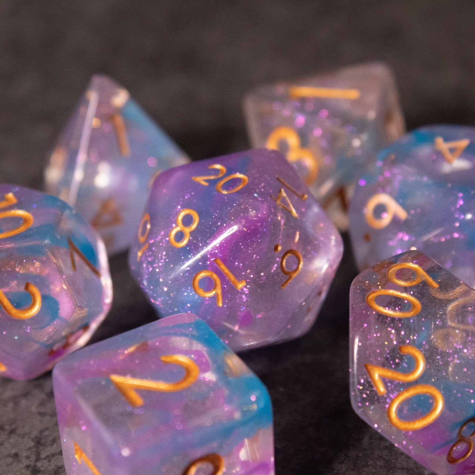 Cotton Candy Dice Set - Set of blue and pink translucent standard dice with gold numbers, featuring a sparkly cotton candy effect.