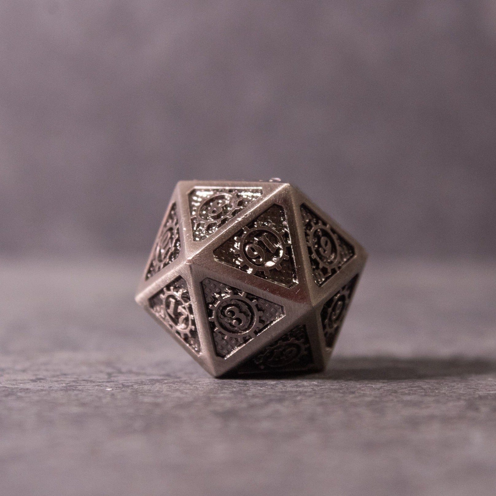 Metal Gear Dice Set - Metal 20-sided dice with intricate filigree design and openwork detailing.