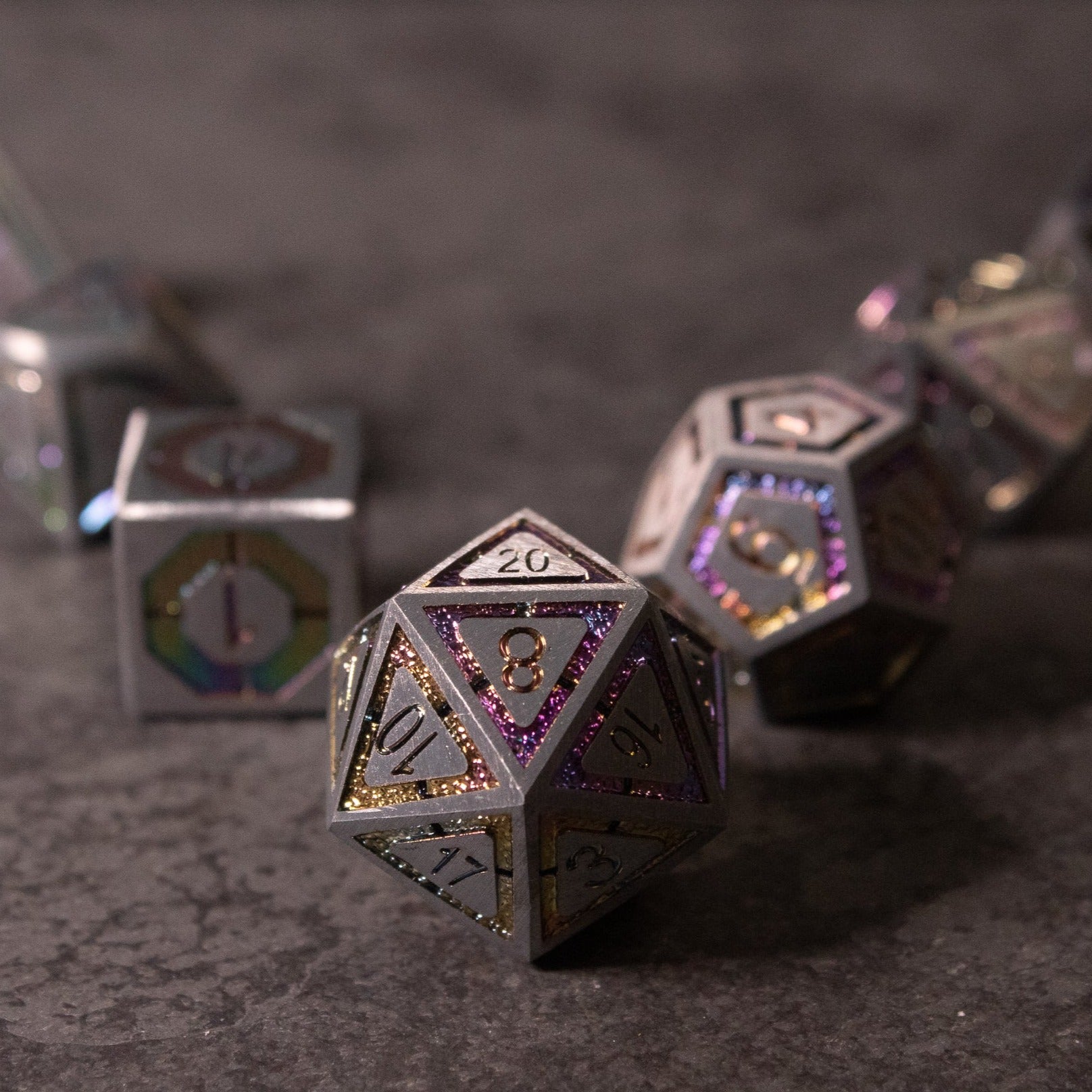 Prismatic Core Dice Set - Silver metal polyhedral dice set with prismatic black and purple etched numbers on a dark textured surface.