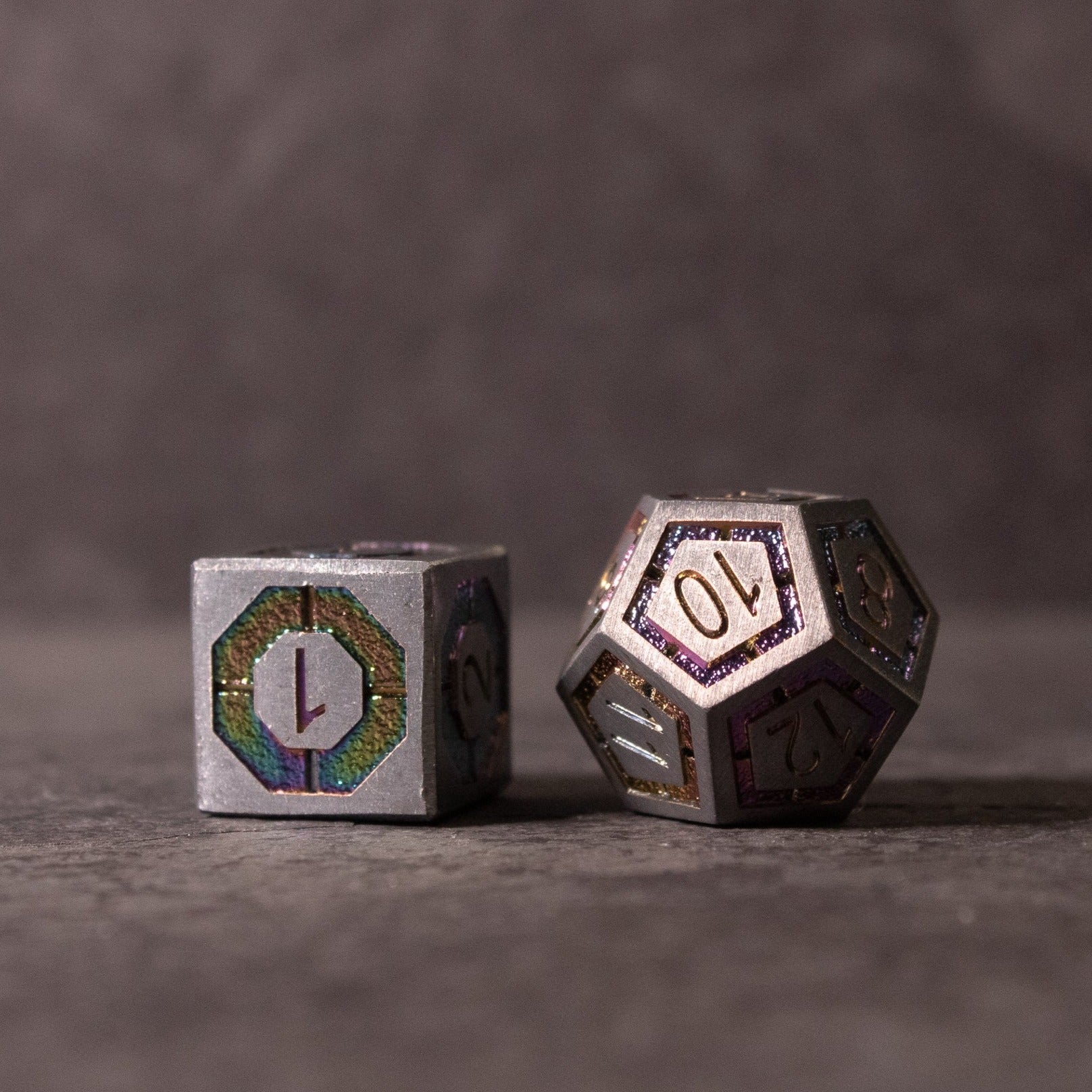 Prismatic Core Dice Set - Metal Prismatic Core dice set with iridescent hexagonal inlays, featuring d20 and d6 shapes.