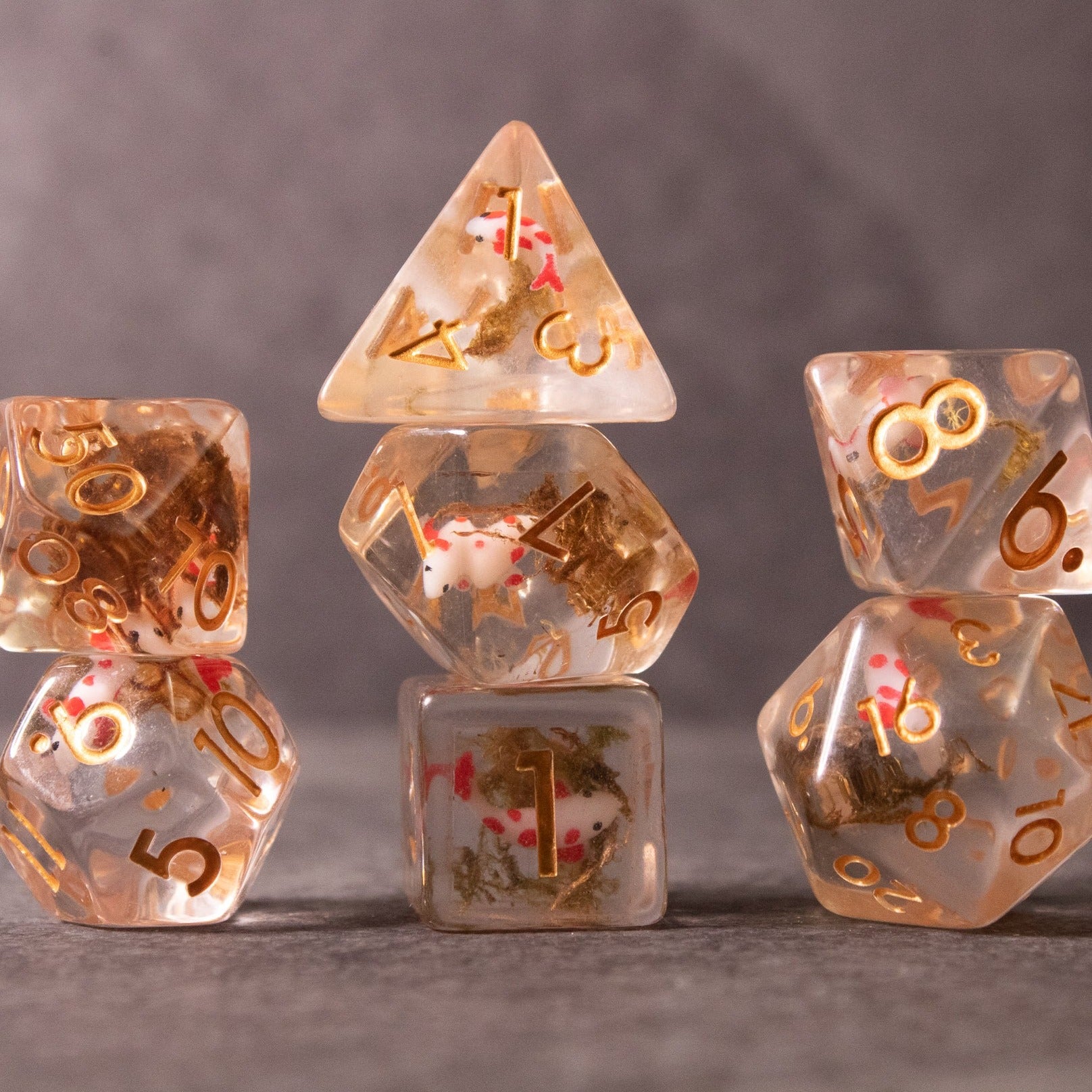 Koi Fish Dice Set - Transparent dice set with gold numbers and colorful koi fish designs inside, arranged on a gray surface.