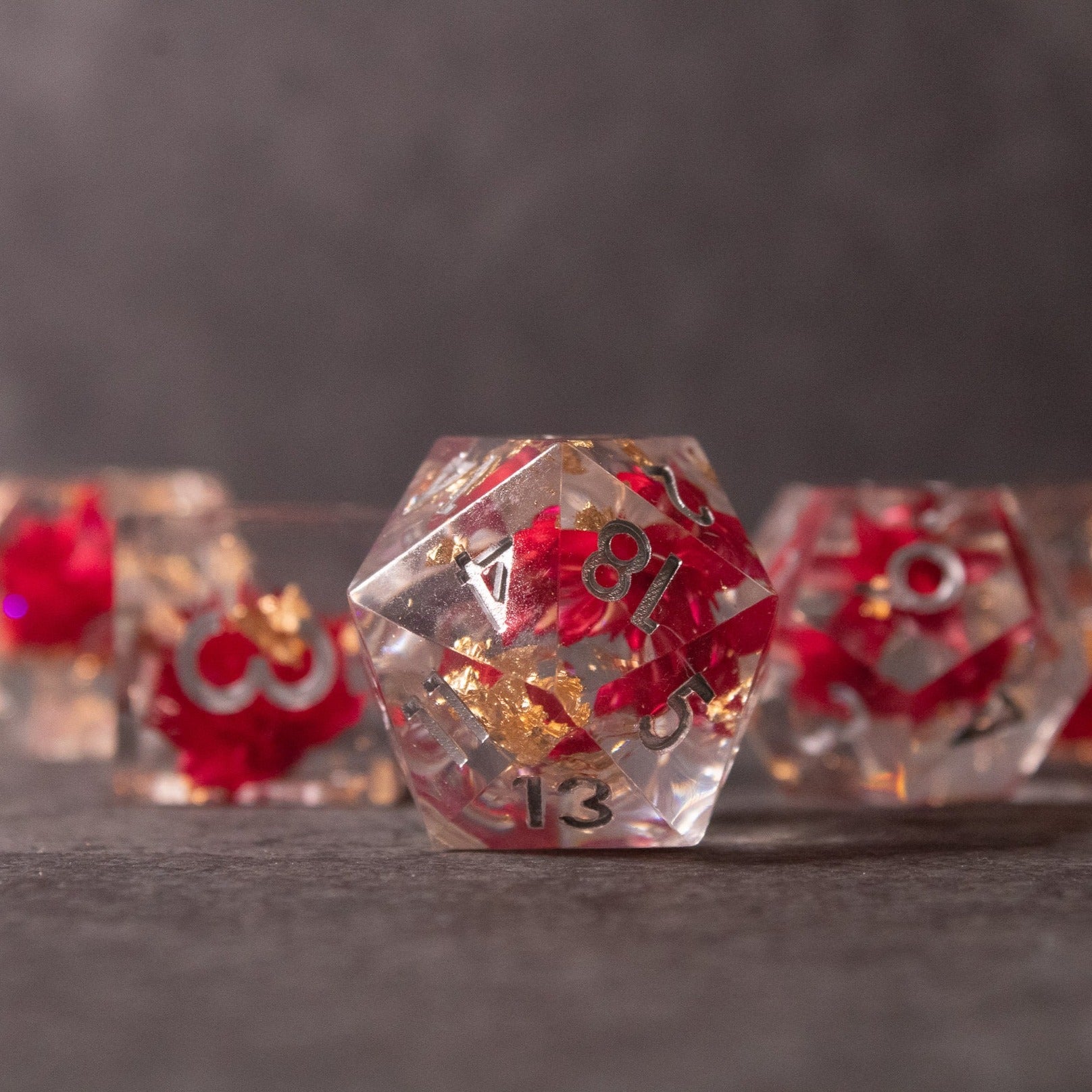 Red Lotus Flower Dice Set - Clear sharp-edged polyhedral dice set with red numbers and gold lotus flower designs inside.