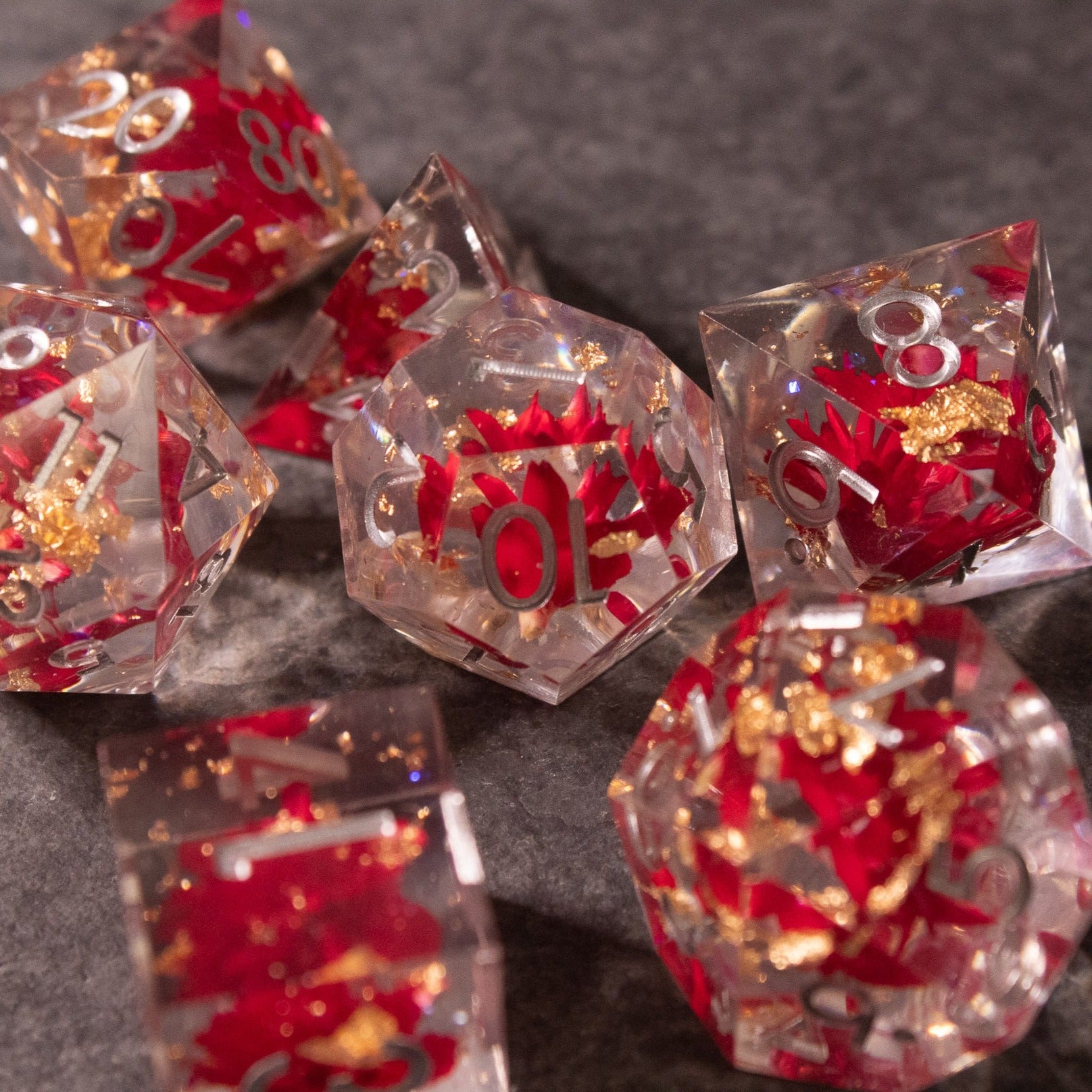 Red Lotus Flower Dice Set - Clear sharp-edged dice with red lotus flower designs and gold flakes inside.