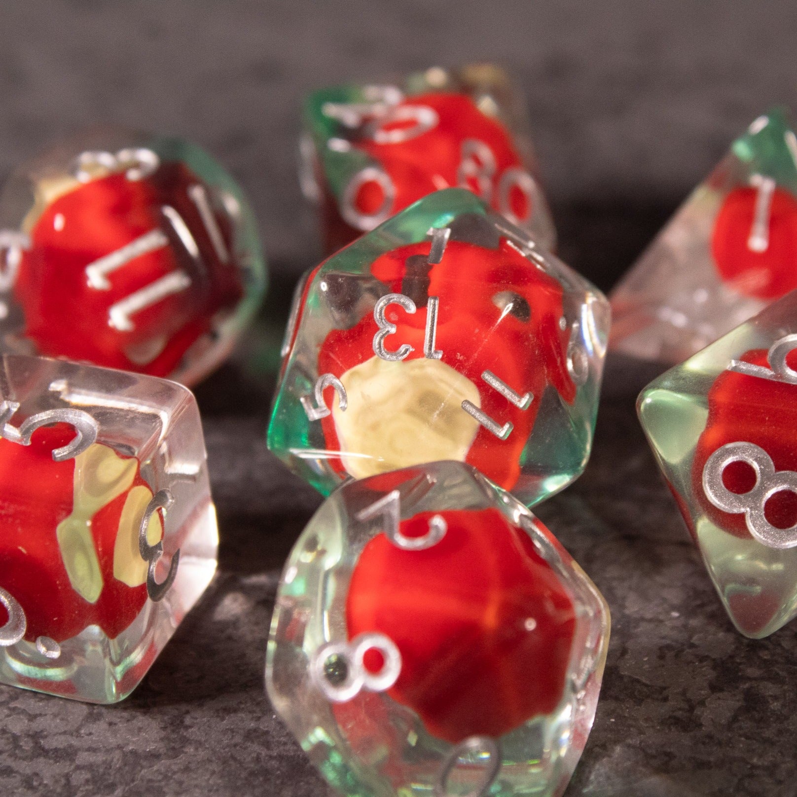Apple Bite Dice Set - Clear polyhedral dice with detailed red apple cores inside, featuring white numbers on each face.