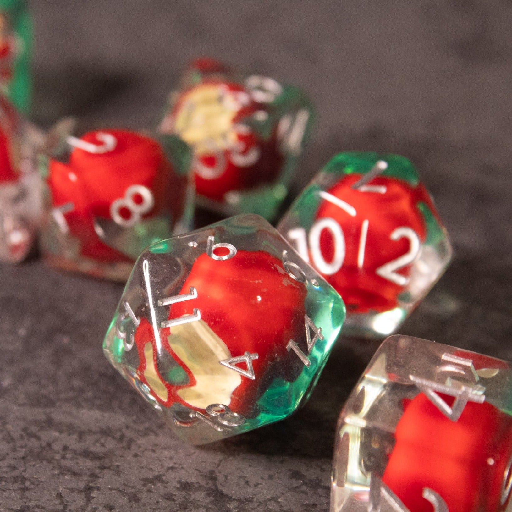 Apple Bite Dice Set - Clear polyhedral dice with small red apples inside each, white numbers on each face.