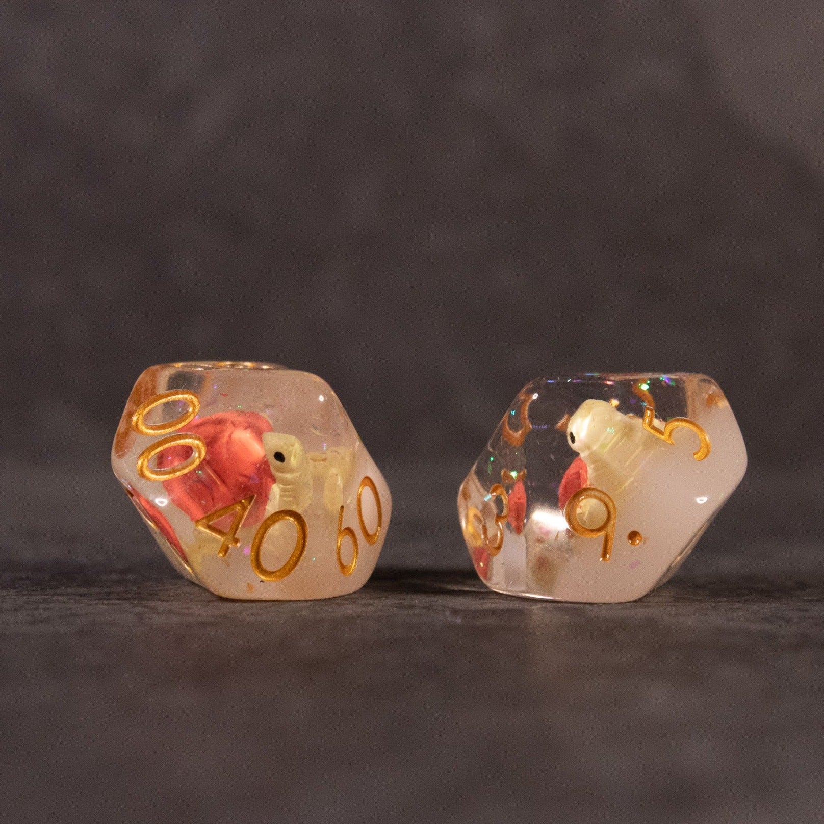 Brown Turtle Dice Set - Two translucent twenty-sided dice with embedded miniature brown turtles and gold numbering on a dark surface.