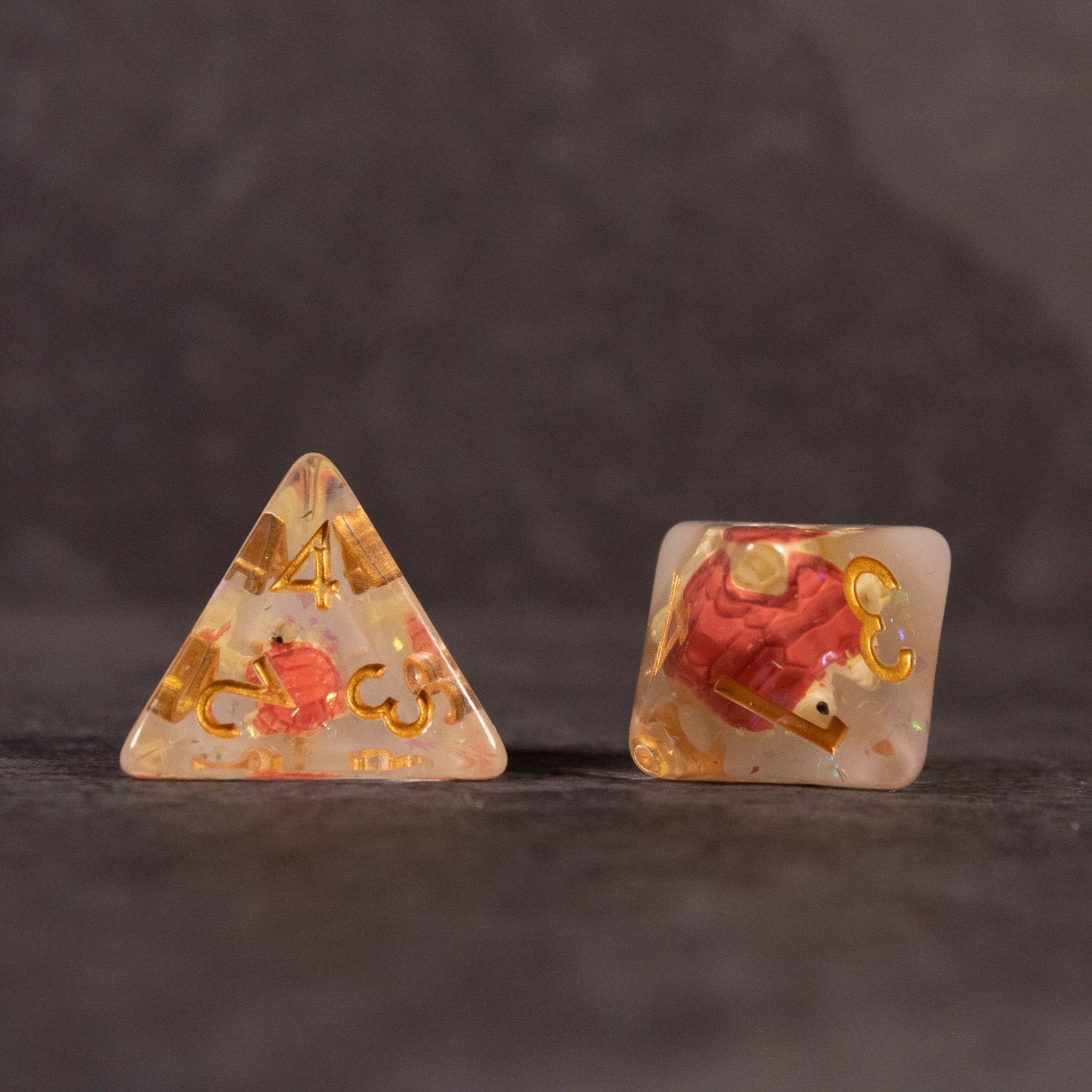 Brown Turtle Dice Set - Clear brown tetrahedron and cube dice with embedded red turtles and gold numbers.