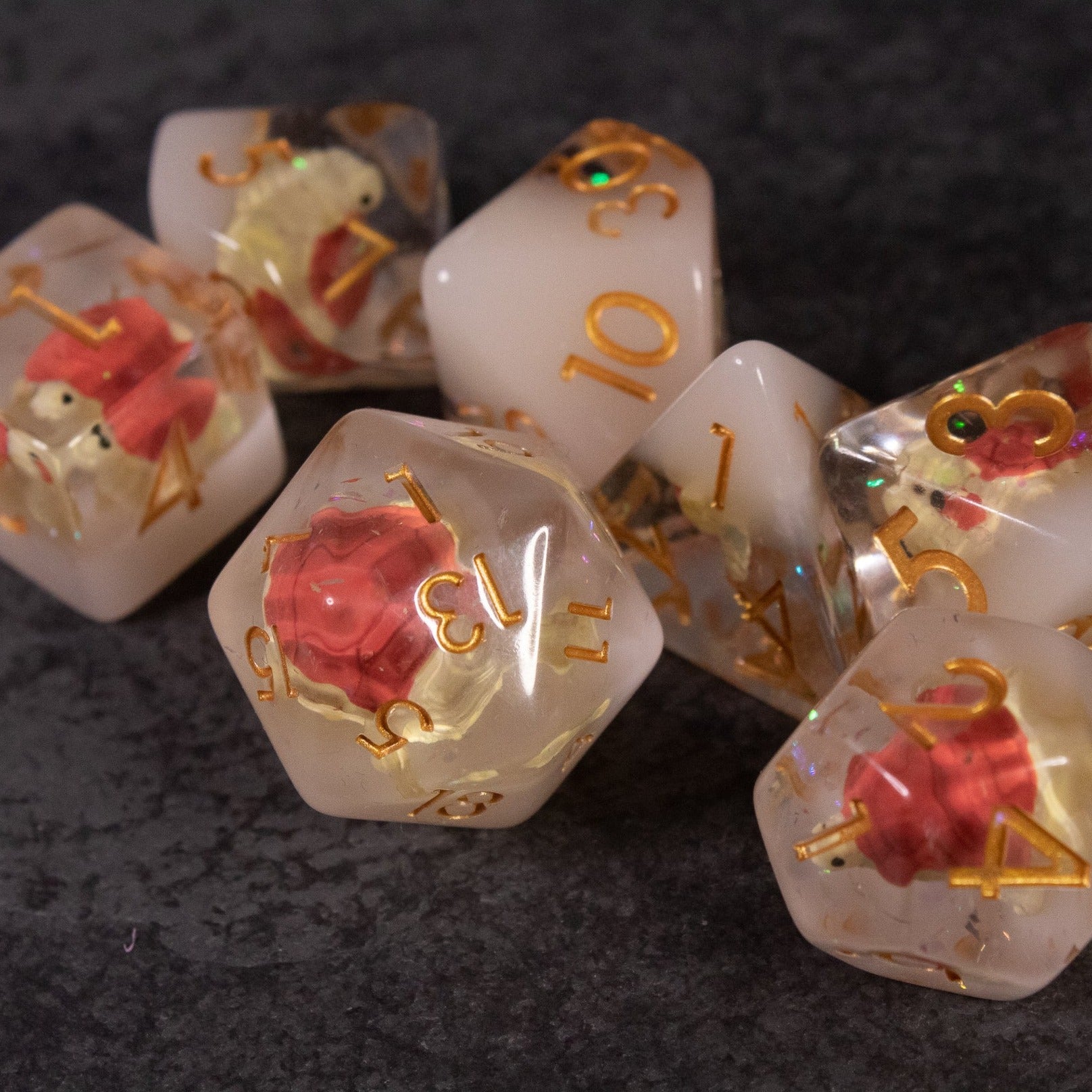 Brown Turtle Dice Set - Set of translucent white polyhedral dice with embedded brown turtle figures and gold numbering.
