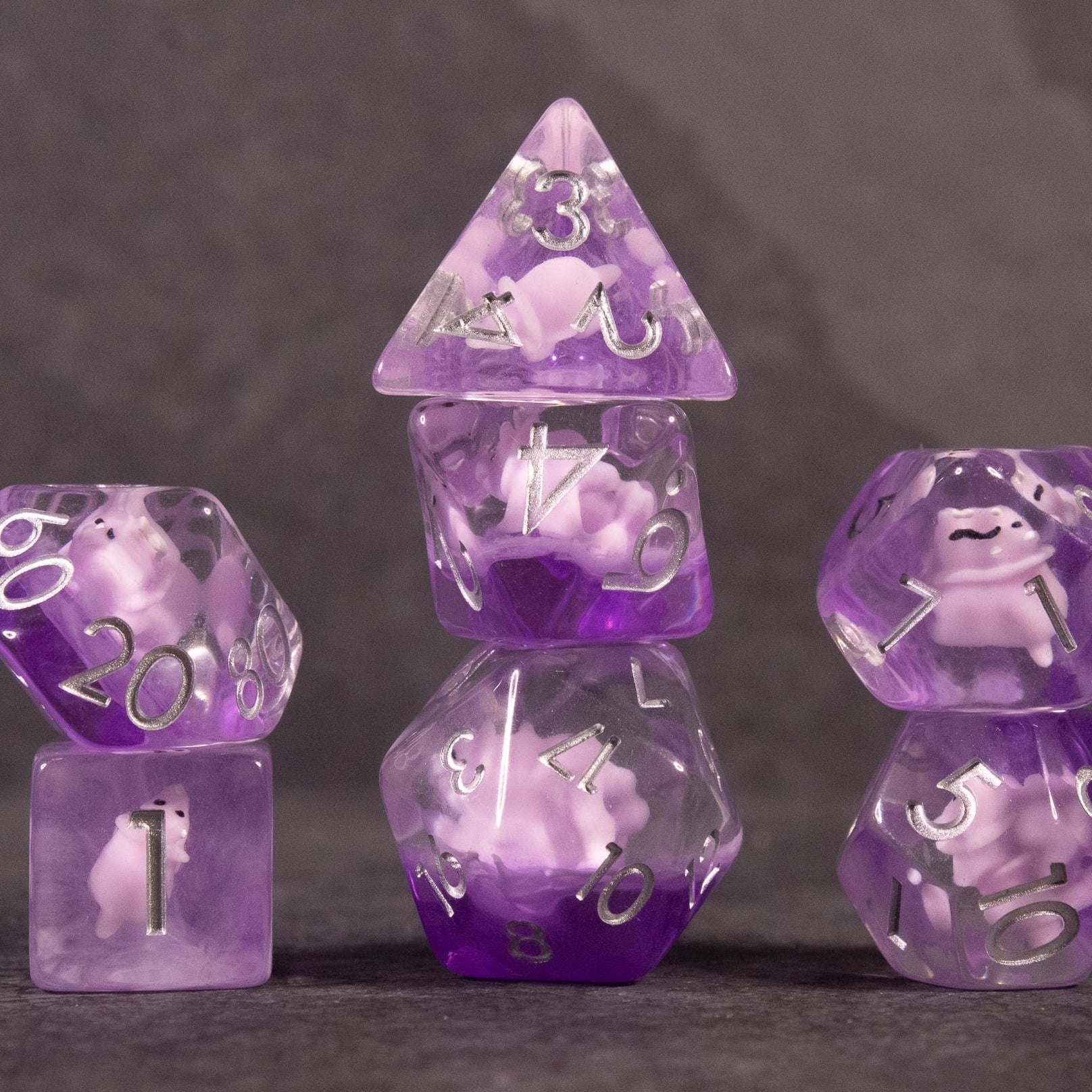 Pink Triceratops Dice Set - Purple and pink translucent dinosaur-themed polyhedral dice set with white numbering.