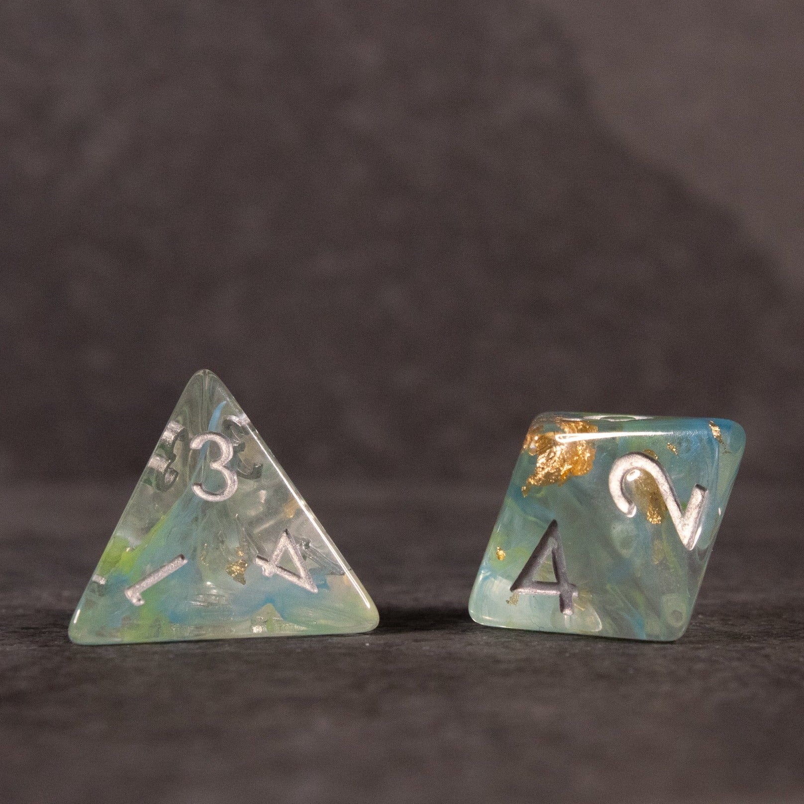Blue, Green, and Gold Swirl Dice Set - Blue, green, and gold swirl four-sided and eight-sided dice with white numbering.