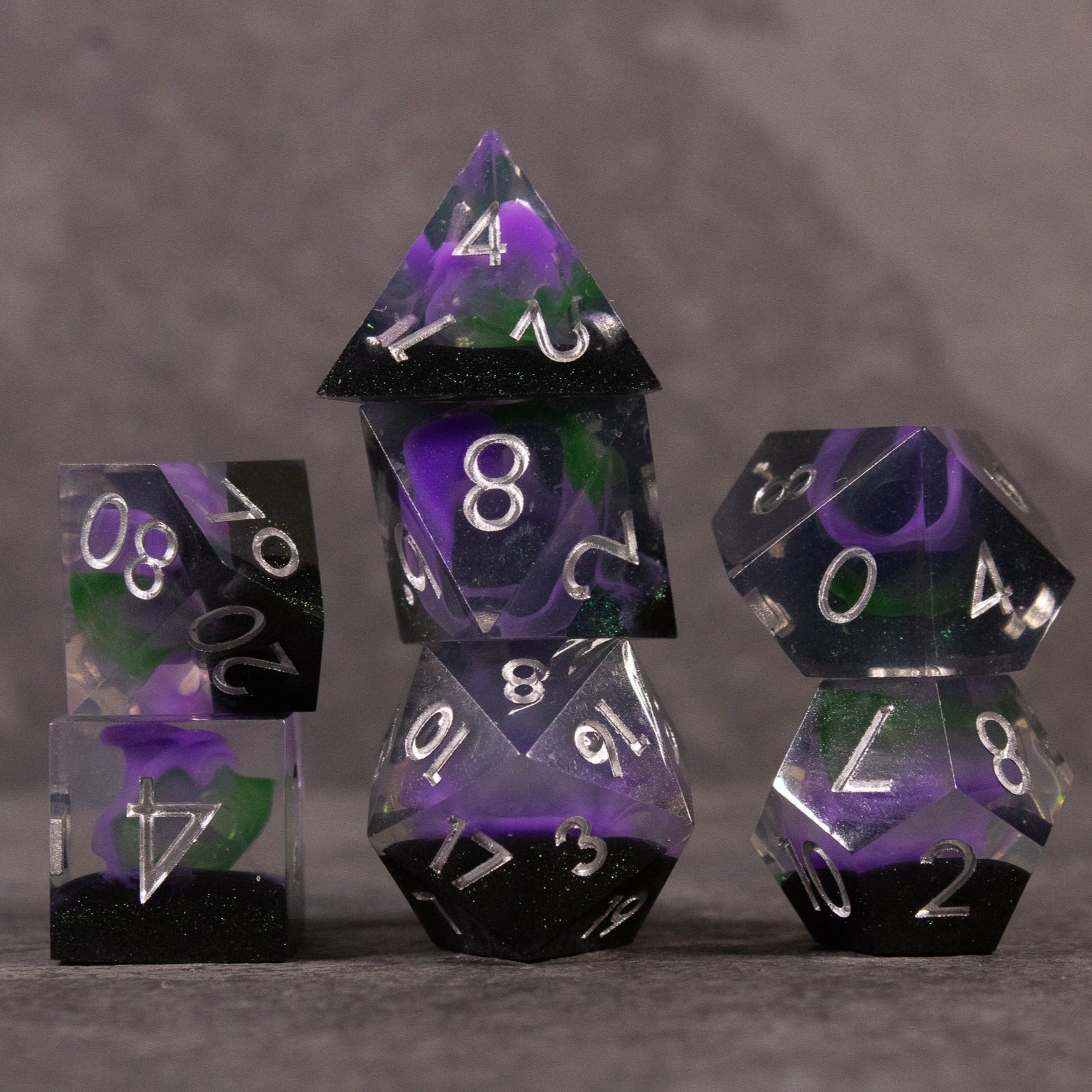 Witch's Brew Dice Set - Set of seven sharp-edged dice in green and purple swirl with white numbers.