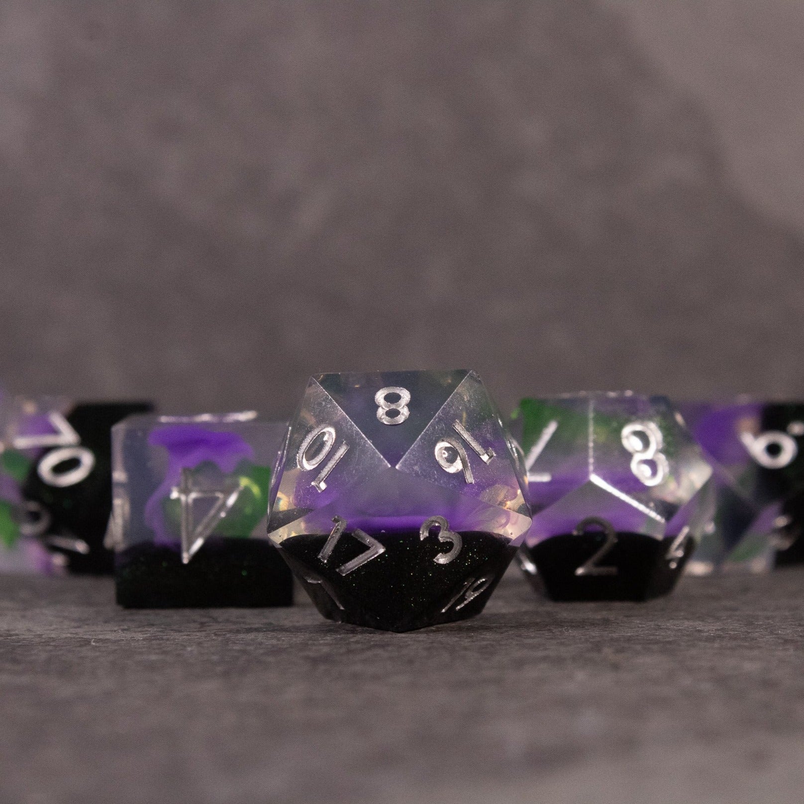 Witch's Brew Dice Set - Set of sharp-edged polyhedral dice in green, purple, and black with white numbering.