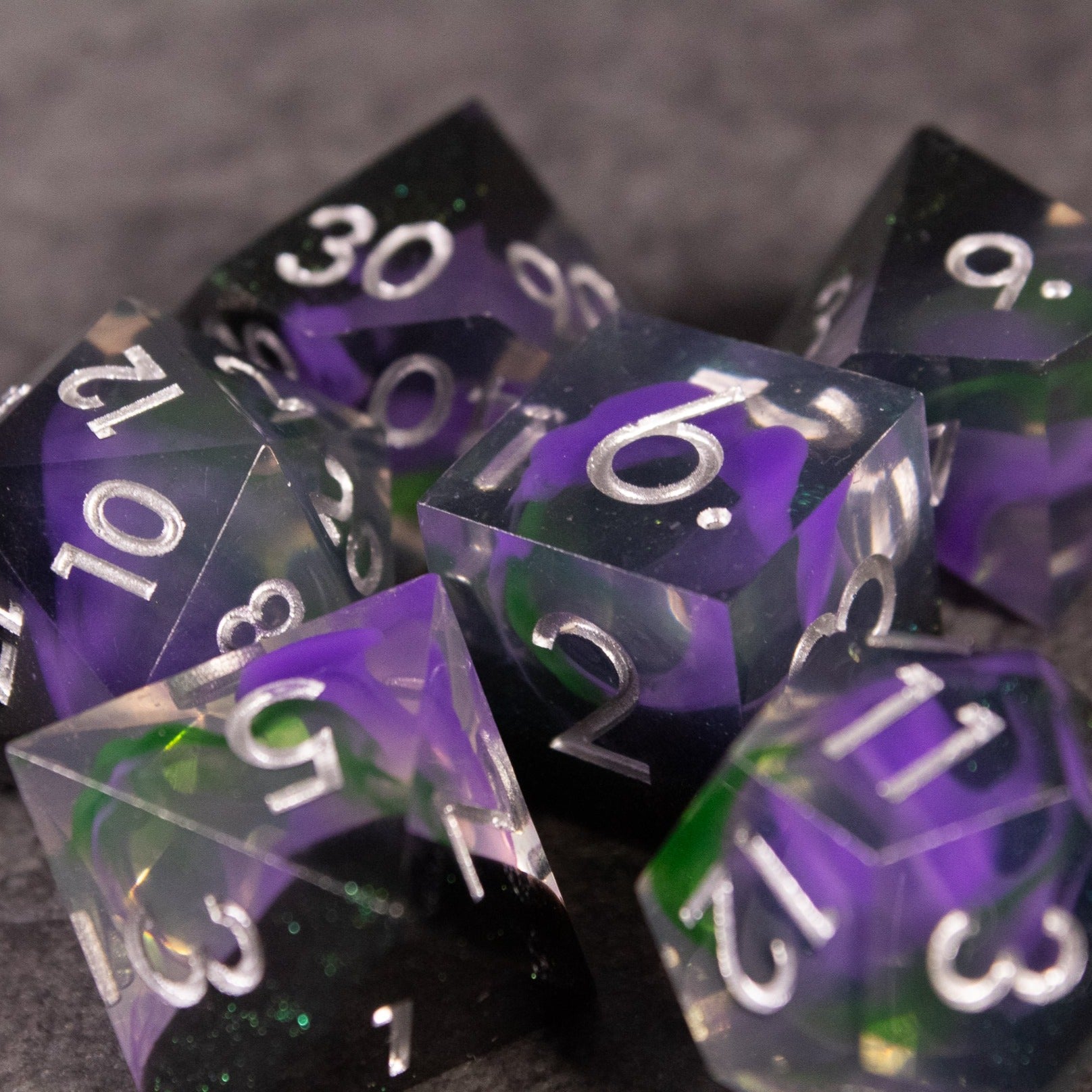 Witch's Brew Dice Set - Sharp-edged dice set with translucent purple and green swirls and white numbering.