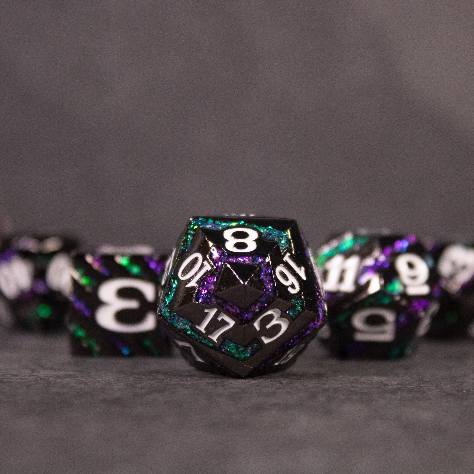 Arcane Leyline Dice Set - Purple & Green - Metal polyhedral dice set with purple and green swirling colors and white numbers, including a 20-sided die in focus.