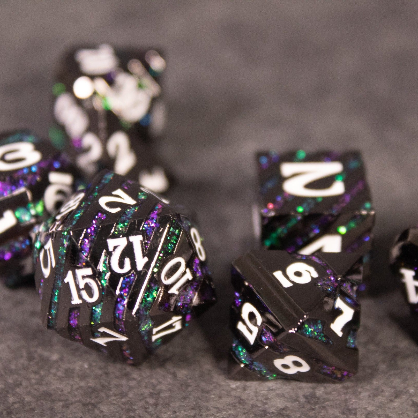 Arcane Leyline Dice Set - Purple & Green - Purple and green metal polyhedral dice set with white numbering and speckled design.