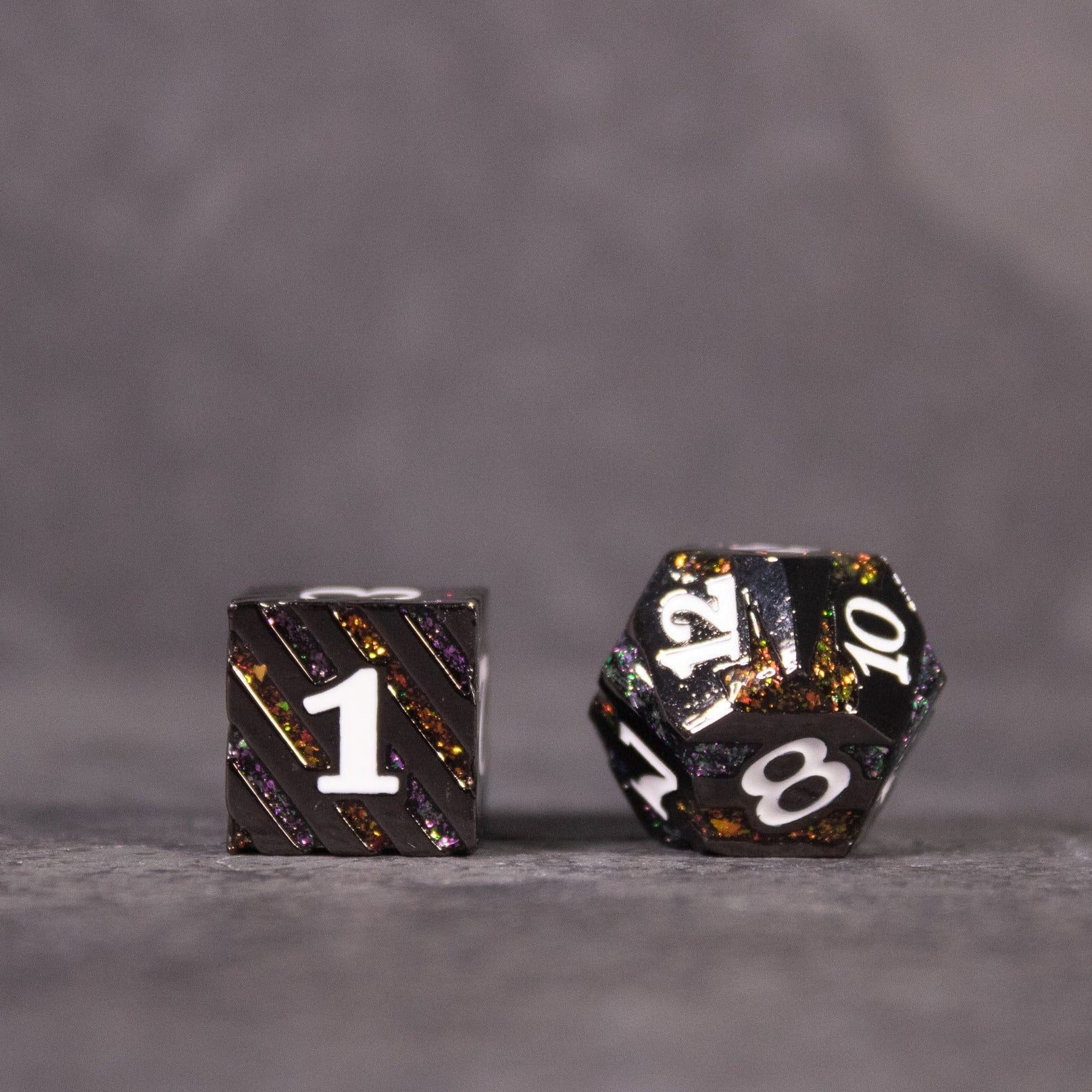 Arcane Leyline Dice Set - Orange & Pink - Black metal gaming dice set with orange and pink speckles, white numbering, includes d6 and d10.