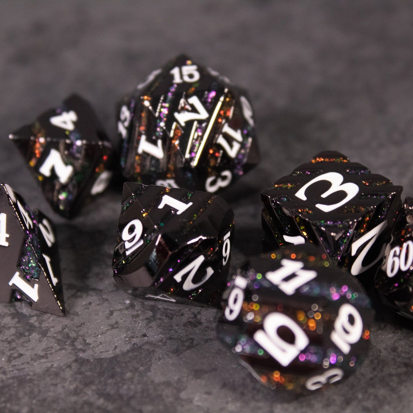Arcane Leyline Dice Set - Orange & Pink - Black metal polyhedral dice set with orange and pink speckles and white numbering.