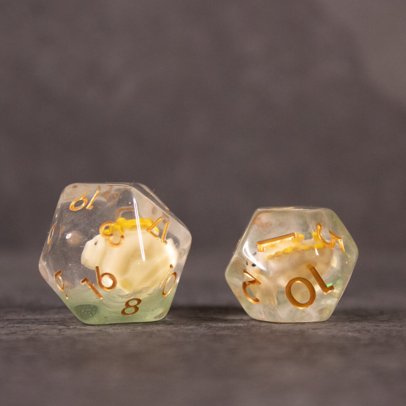 Yellow Stegosaurus Dice Set - Two translucent yellow 10-sided dice with gold numbers, featuring small yellow stegosaurus figures inside each die.
