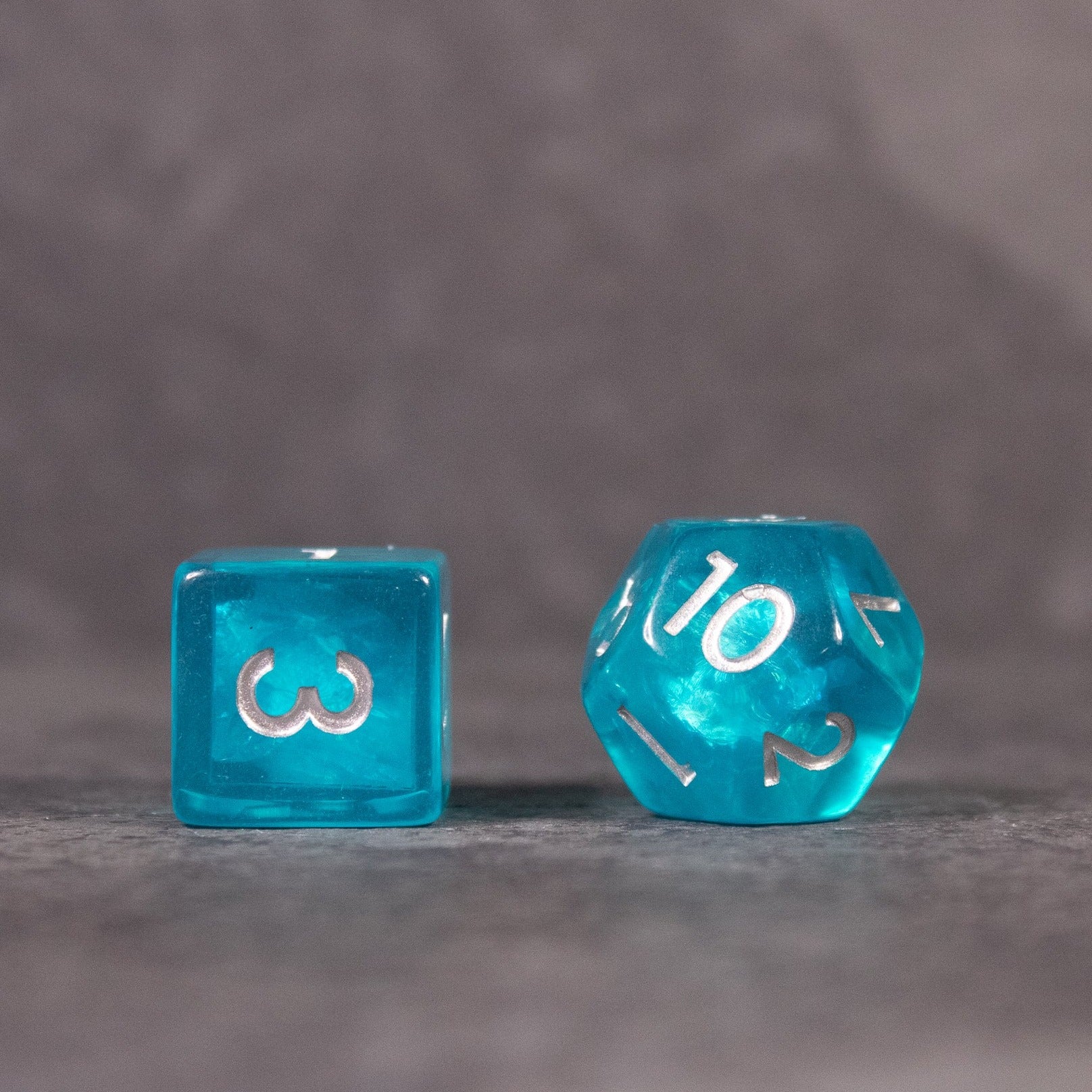 Teal Blue Dice Set - Teal blue translucent dice set featuring a six-sided die and a twenty-sided die with white numbering.