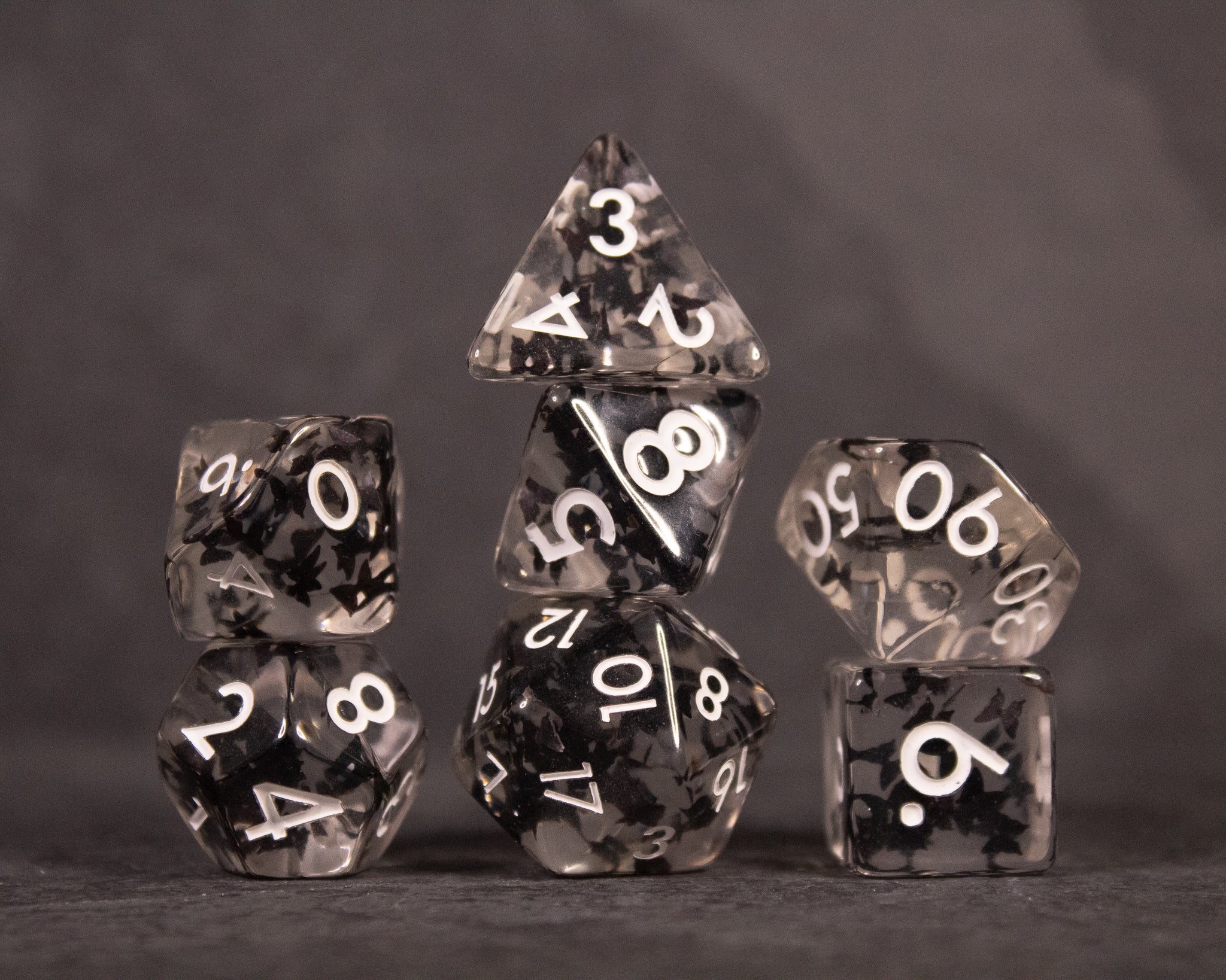 Black Butterfly Dice Set - Black translucent dice set with white numbers and butterfly wing patterns, including d20, d12, d10, d8, d6, and d4.