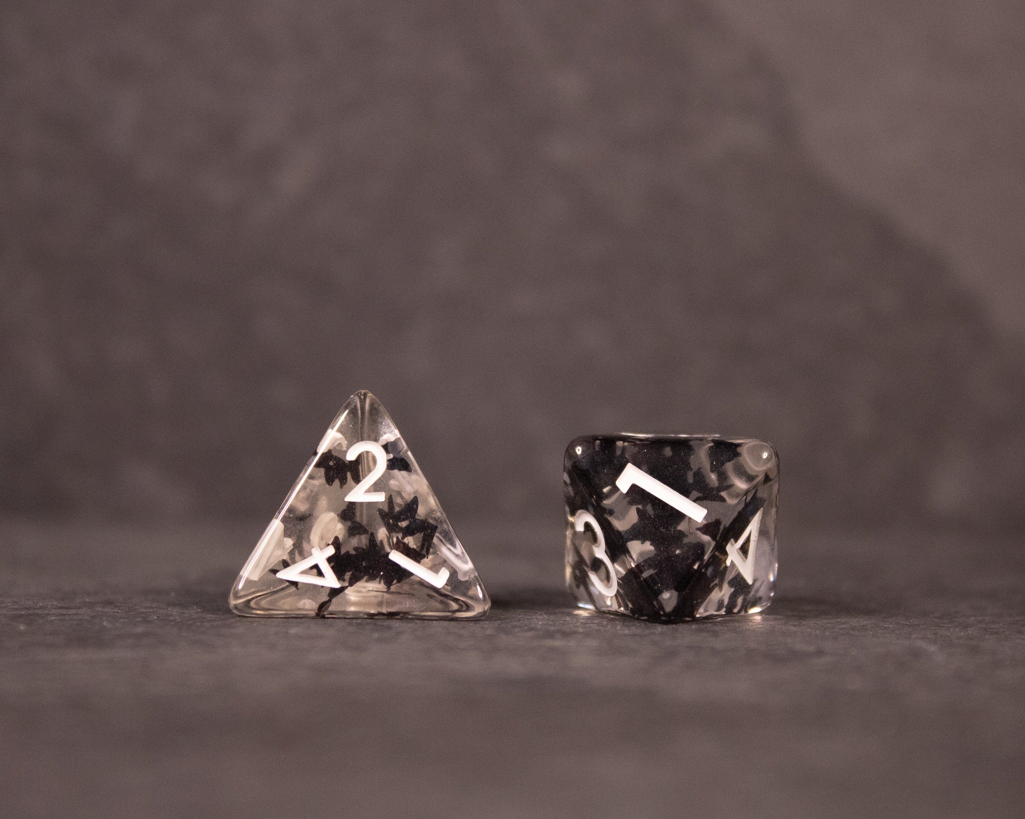 Black Butterfly Dice Set - Black and white marbled four-sided and six-sided dice with white numbering, featuring a mix of translucent and solid areas.