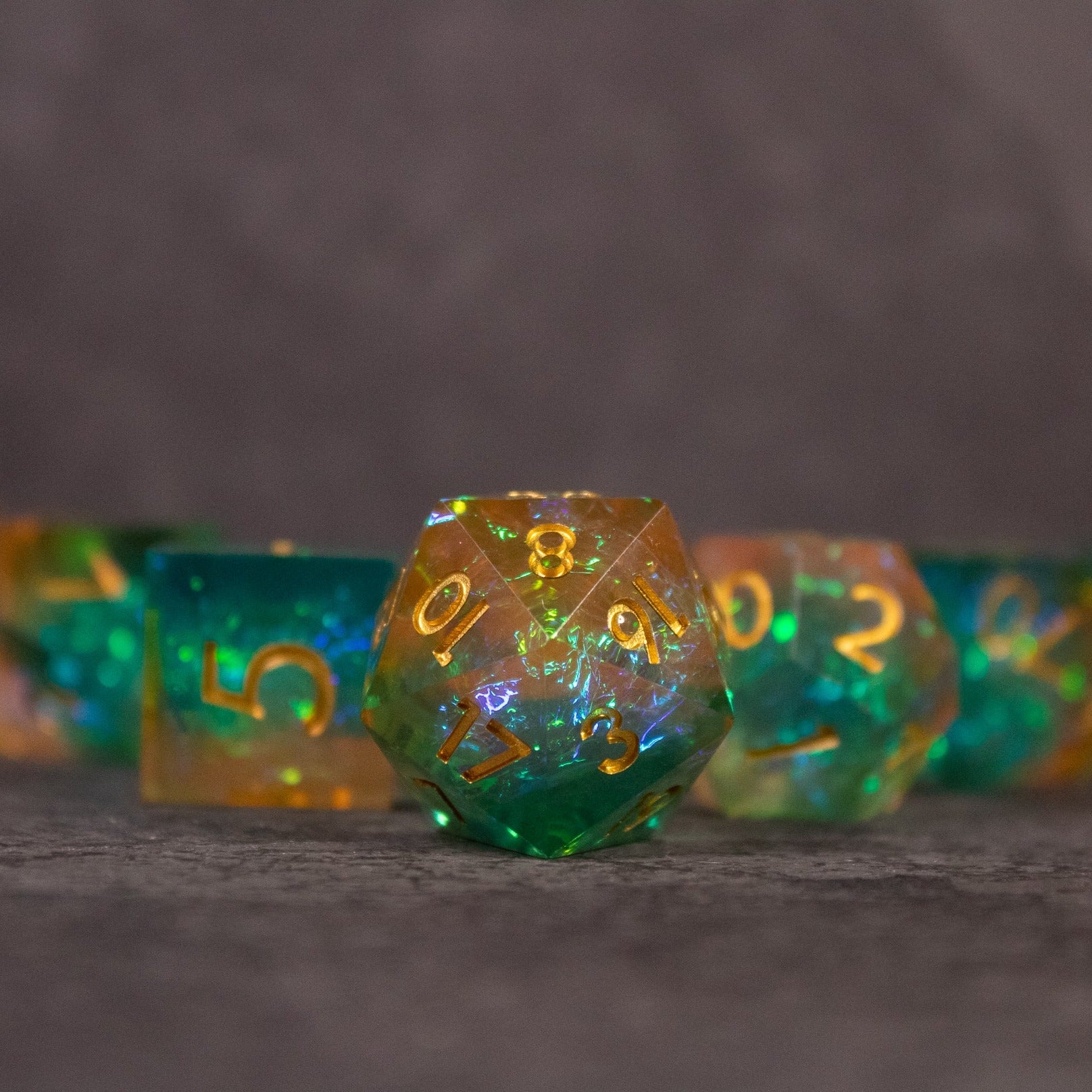 Seafarer Dice Set - Green and orange sharp-edged 20-sided dice with gold numbering from Seafarer Dice Set.