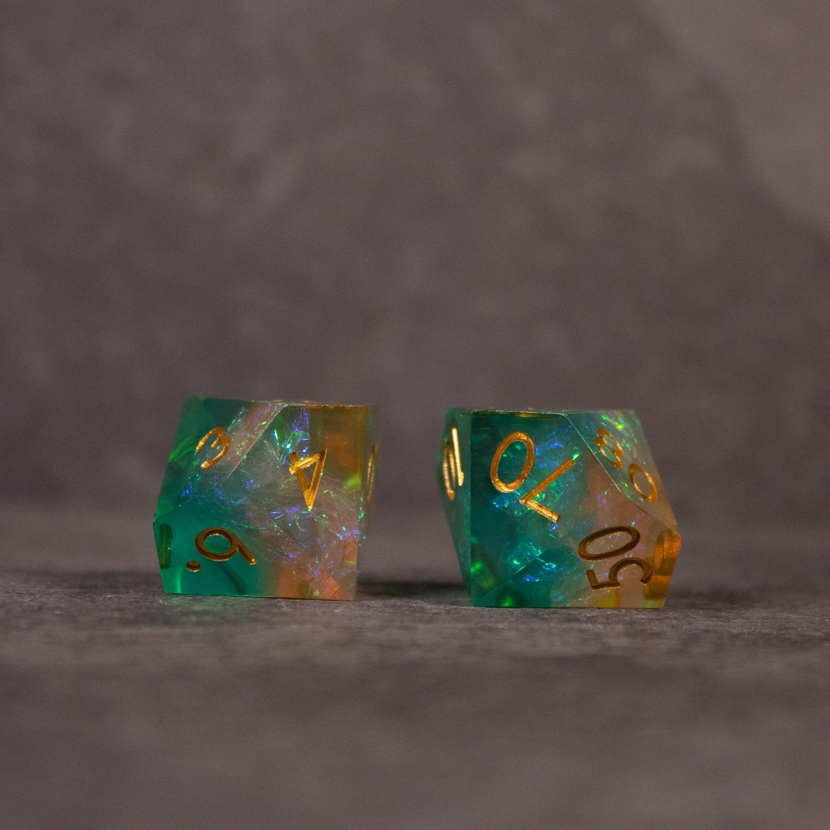 Seafarer Dice Set - Green and orange translucent sharp edge 20-sided dice with gold numbers.