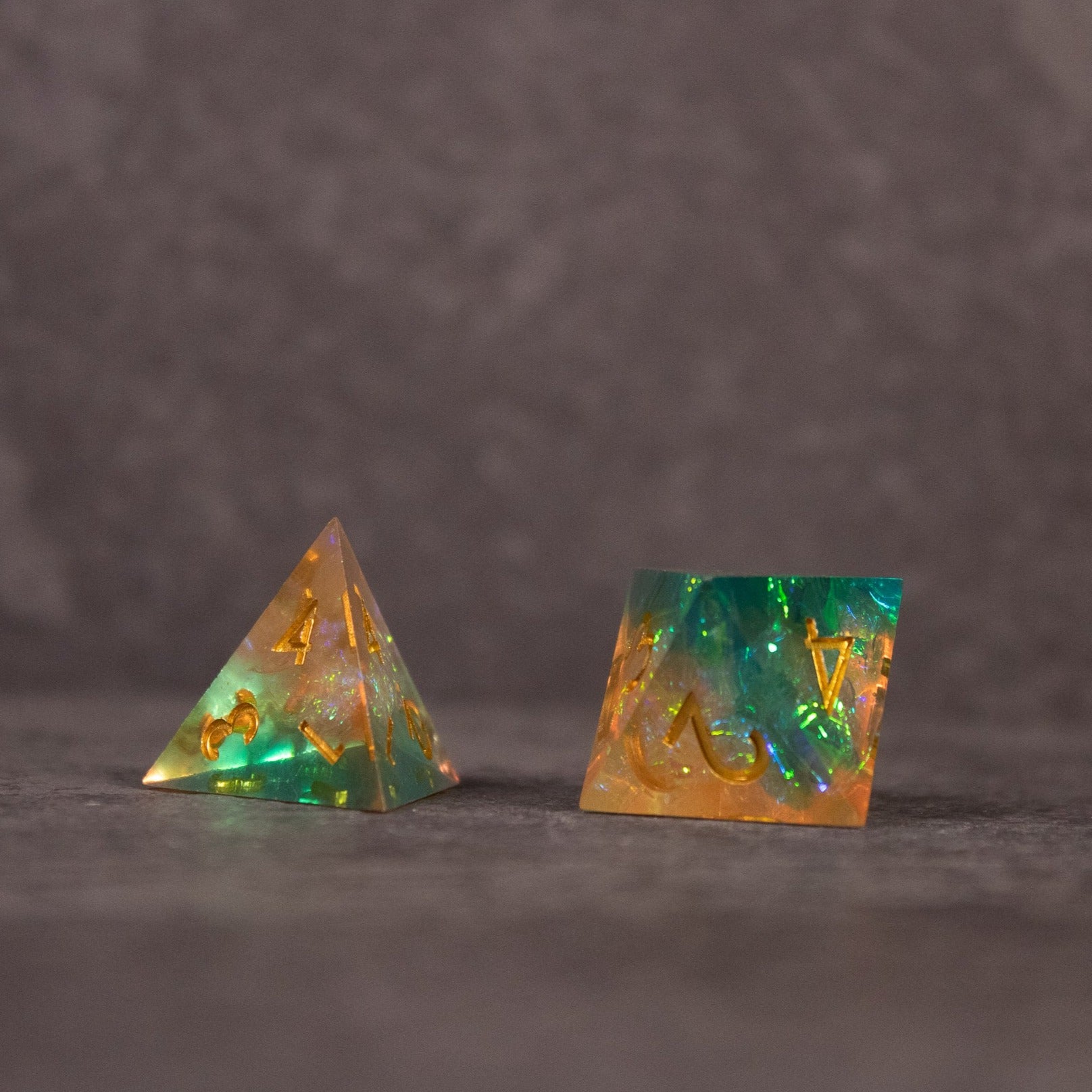 Seafarer Dice Set - Green and orange sharp-edged tetrahedron and cube dice with a translucent finish.