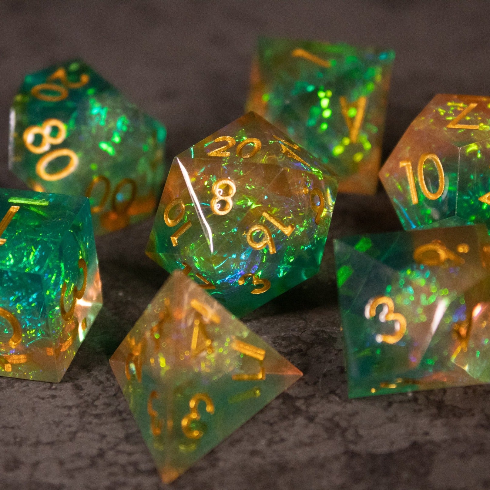 Seafarer Dice Set - Set of seven translucent sharp-edged dice with green and orange swirls and gold numbers.