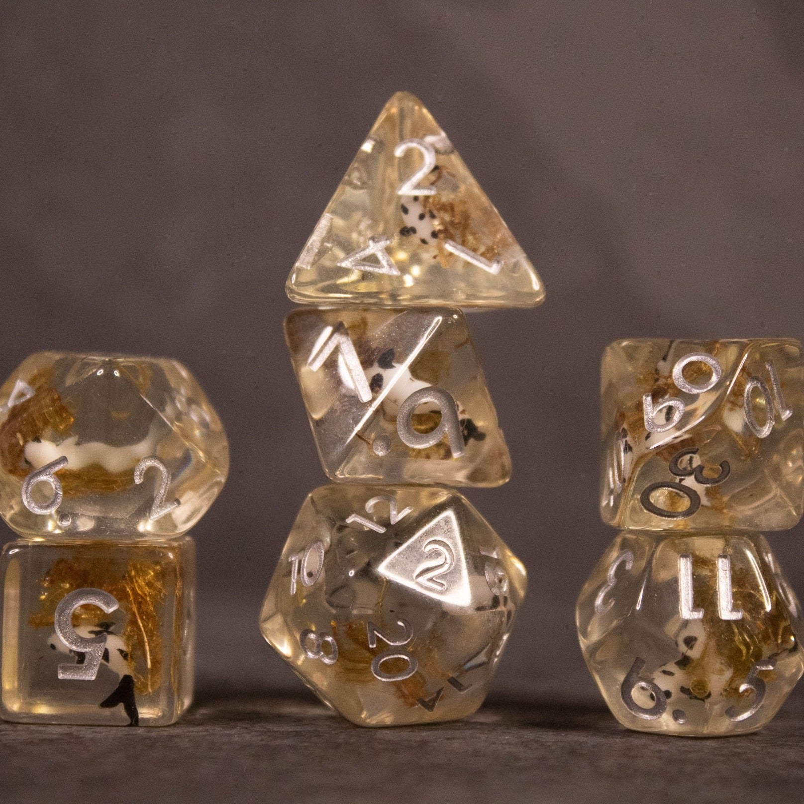 Koi Pond Dice Set - Transparent polyhedral dice set with gold flecks and white numbering, including d20, d12, d10, d8, d6, and d4.