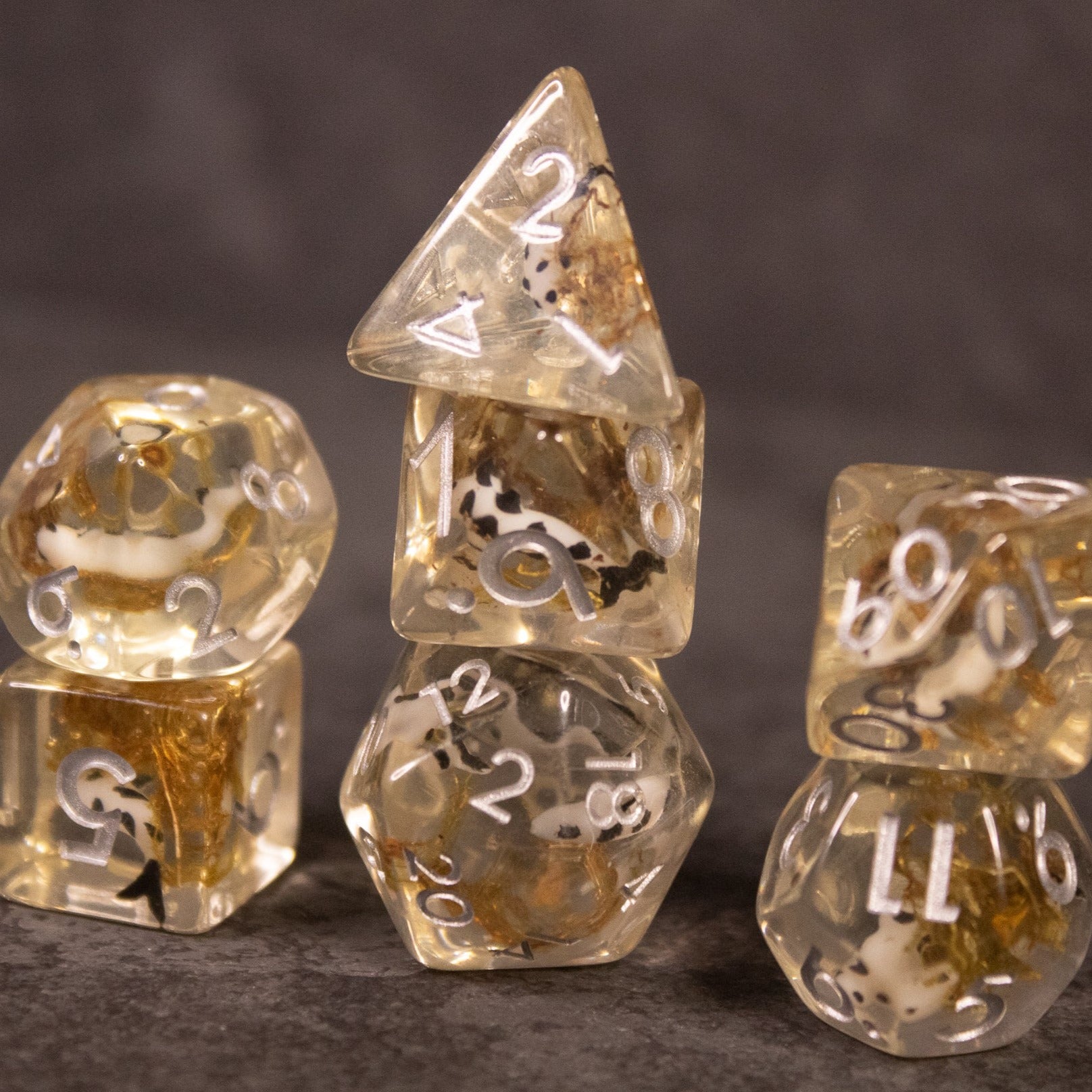 Koi Pond Dice Set - Clear resin dice set with embedded gold flakes and white numbering, featuring multiple polyhedral shapes.