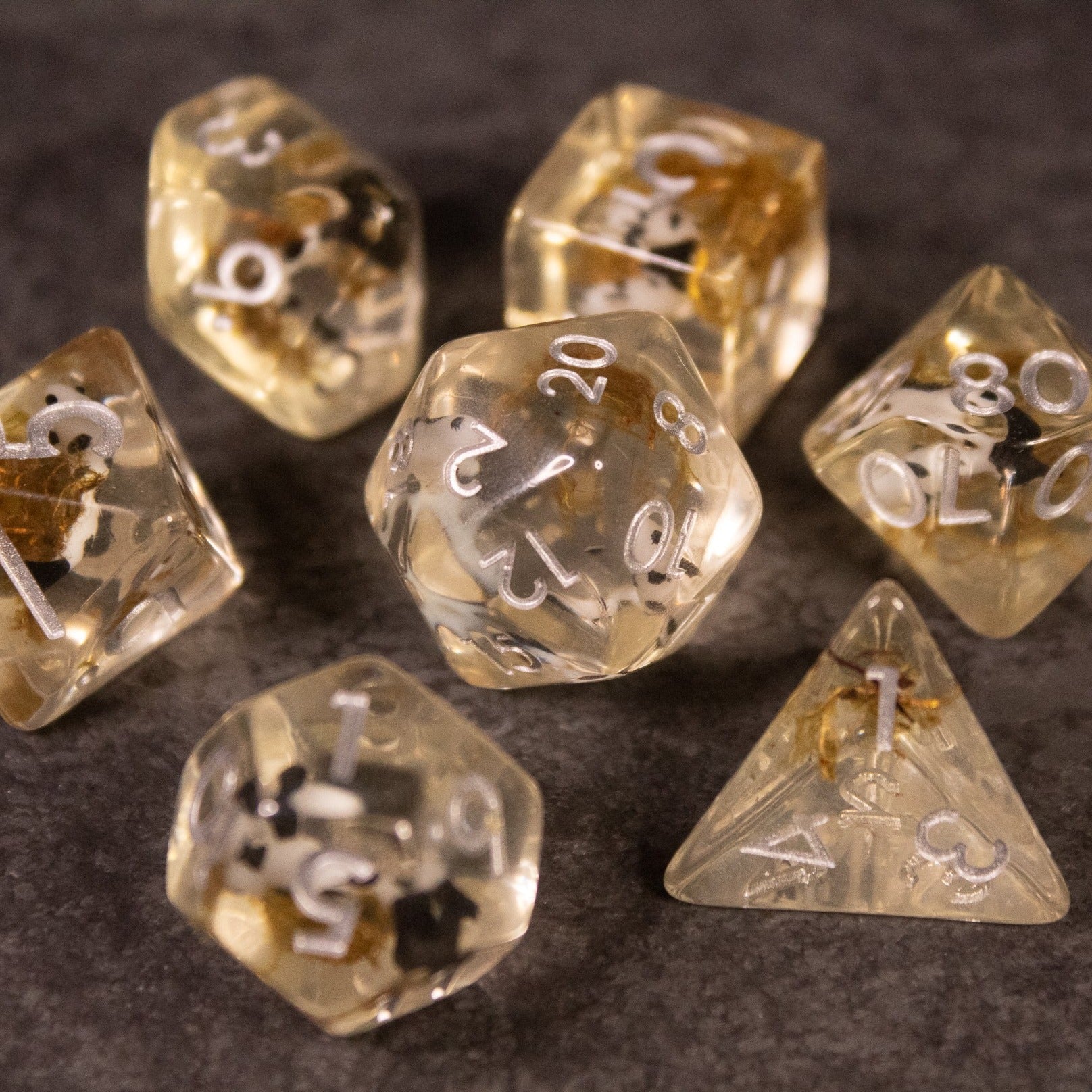 Koi Pond Dice Set - Translucent amber polyhedral dice set with white numbers and delicate koi fish designs inside.